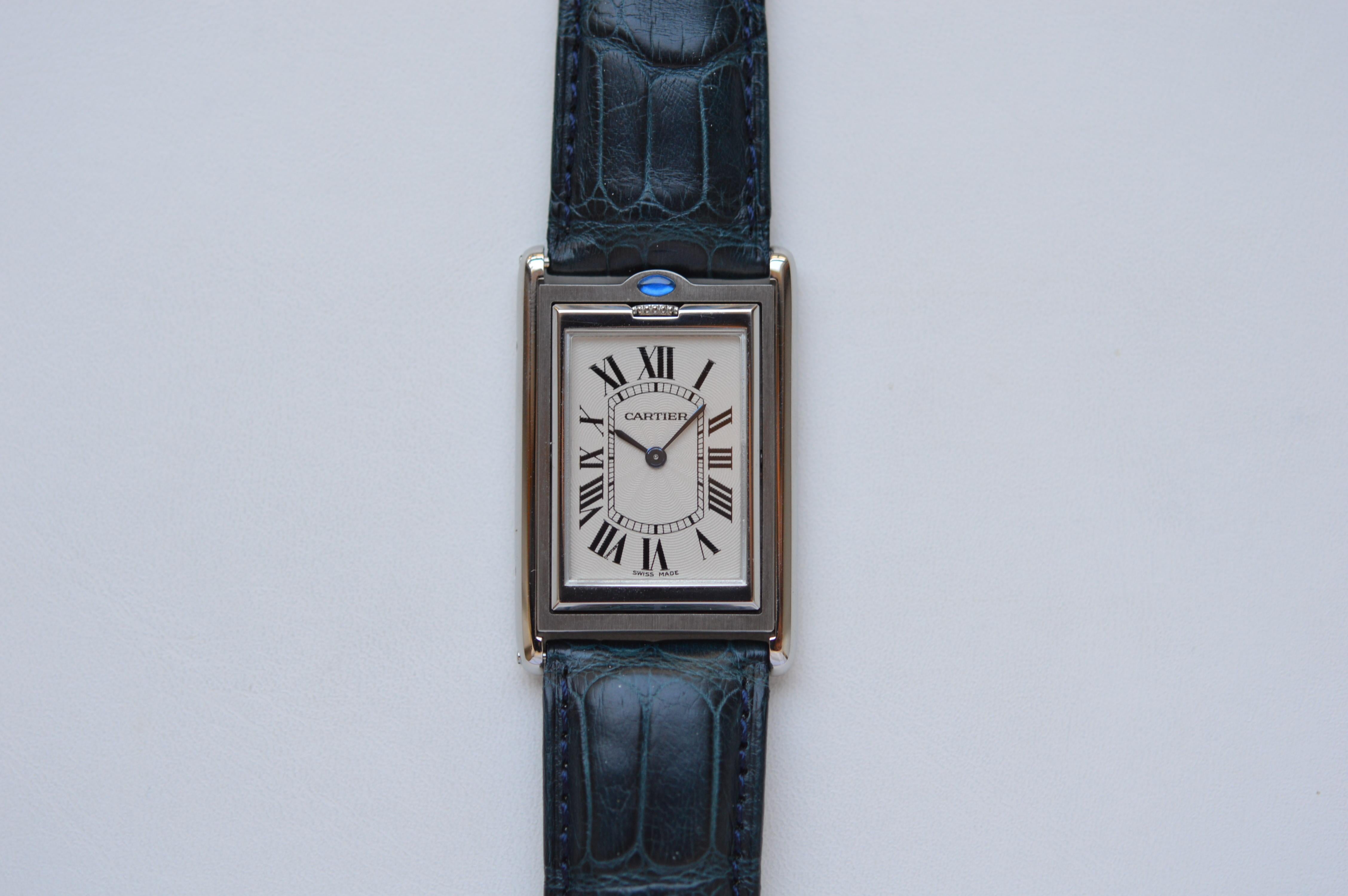 Cartier Tank Basculante Large Model
Reference n° W1011358
31mm X 25mm Size
Large Size
Stainless Steel Case & Buckle
Blue Leather Strap
Blue Sapphire Cabochon Crown
Cream White Dial with Roman Numerals
Blued Steel Sword Shaped Hands
Water Resistant