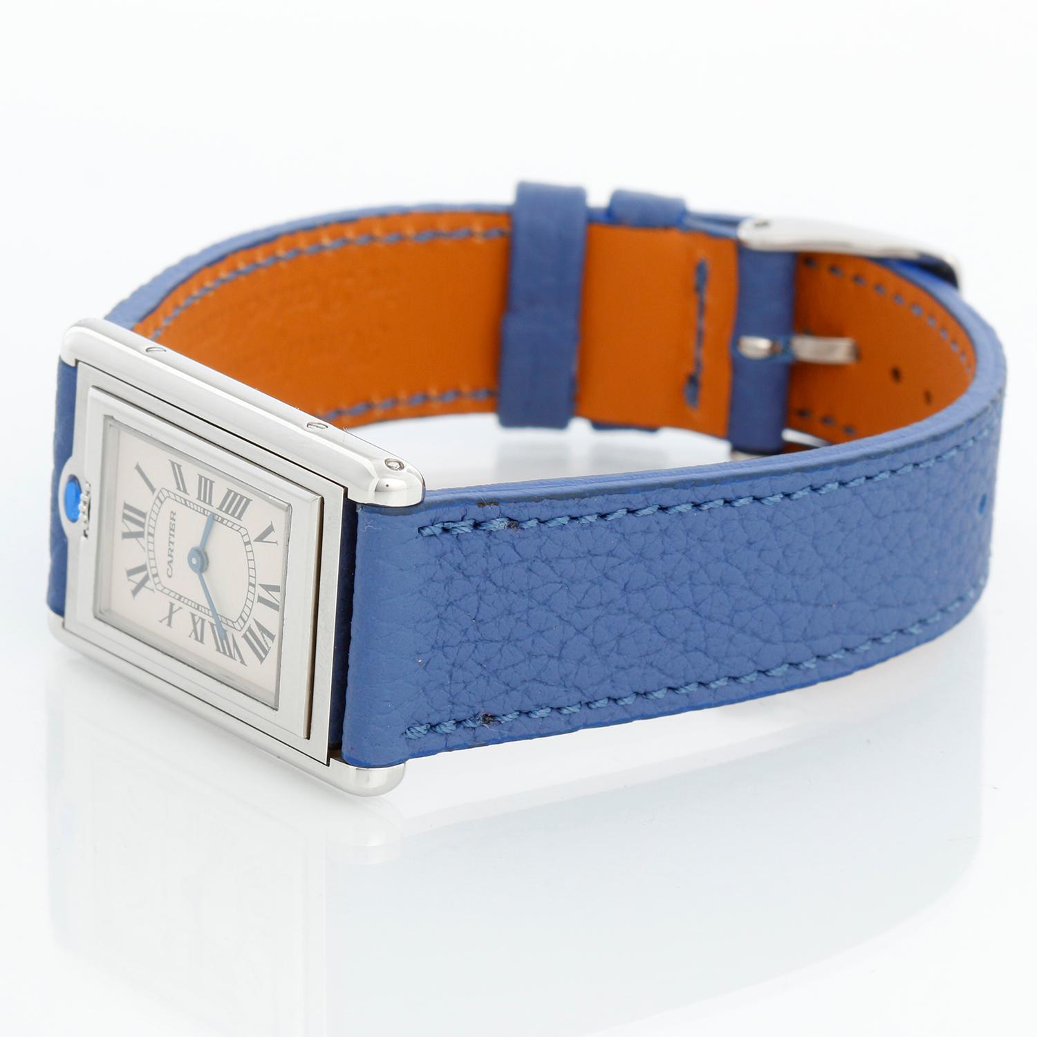 Cartier Tank Basculante Watch Ref 2405 Ladies - Quartz. Stainless steel case ( 24 mm x 36 mm ). Silver dial with Roman numerals. Blue strap with tang buckle . Pre-owned with custom box.