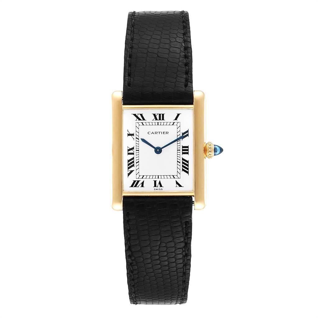 Cartier Tank Classic Paris Yellow Gold Ultra Thin Mechanical Mens Watch. Ultra thin hand made manual winding movement. 18k yellow gold case 23.0 x 30.0 mm. Circular grained crown set with the blue sapphire cabochon. 18K yellow gold bezel. mineral