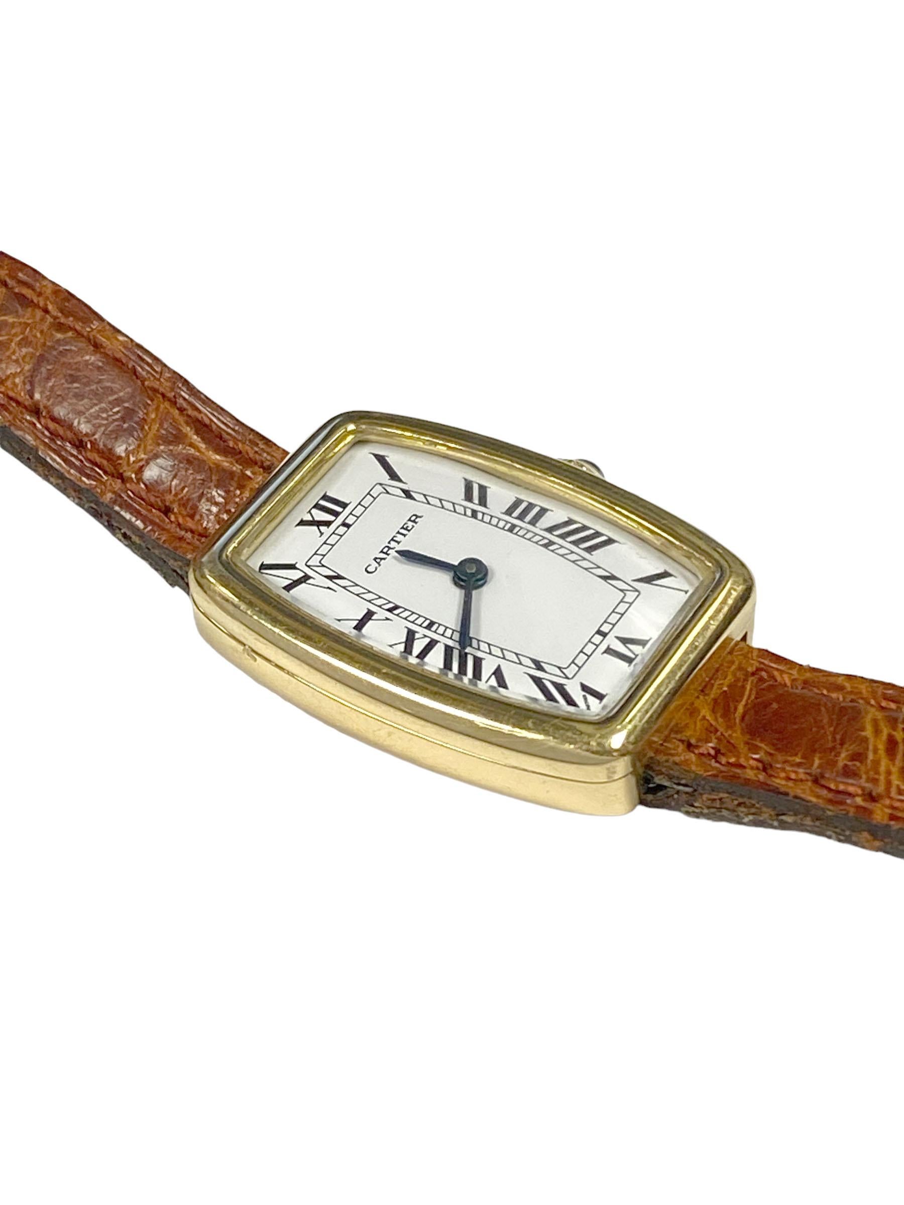 Circa 1970s Cartier Tank Faberge Tonneau Ladies Wrist Watch, 26 X 20 M.M. 18k Yellow Gold 2 Piece Case, Sapphire Crown, 17 Jewel Nickle Lever, Mechanical, Manual wind movement. White Dial with Black Roman Numerals and Blue steel hands. 3/8 inch wide