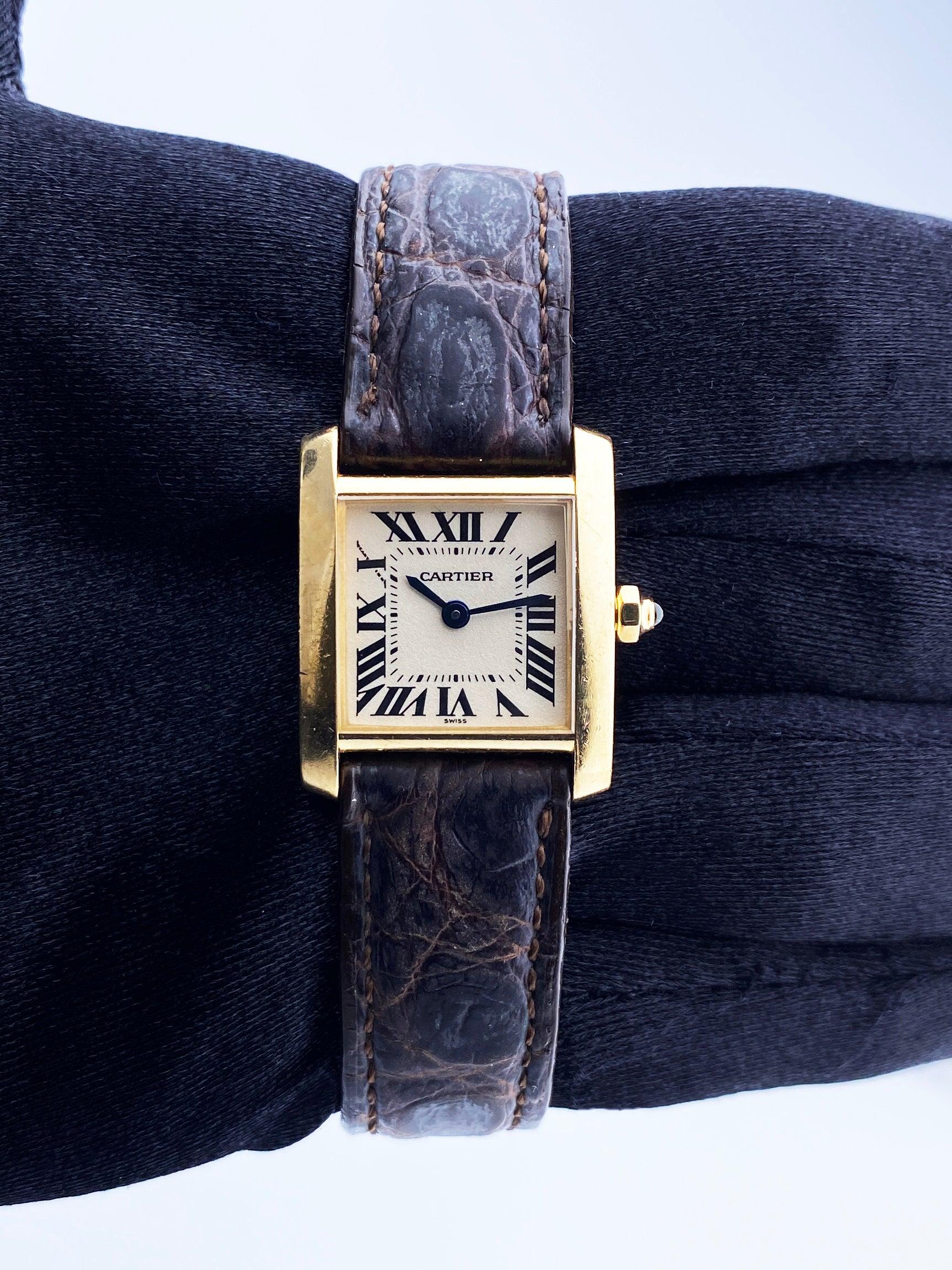 Cartier Tank Francaise 1820 Ladies Watch. 20mm 18k Yellow Gold case with 18K yellow gold smooth bezel. Off-White dial with Blue steel hands and Roman numeral hour markers. Minute markers on the inner dial. Brown leather strap with 18K yellow