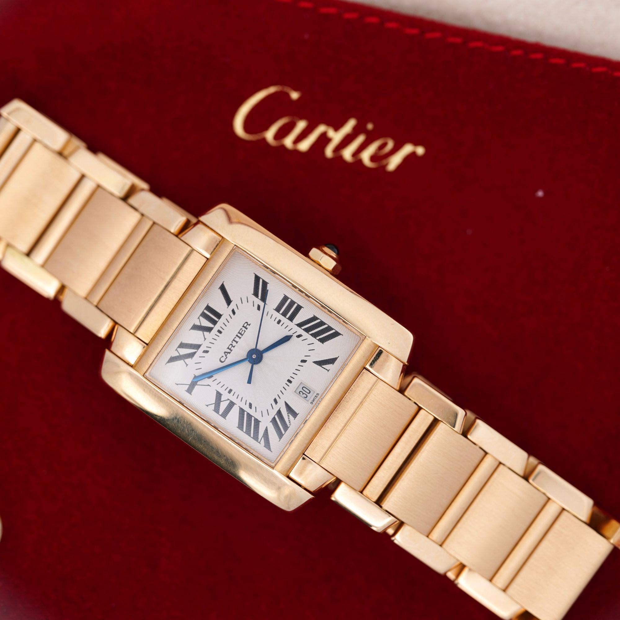 Reloj automático Cartier Tank Francaise de oro amarillo de 18 quilates con caja rectangular de 28 mm, esfera con números romanos, agujas de acero azulado y ventanilla de fecha a las 6. La pulsera integrada con eslabones cepillados y pulidos se