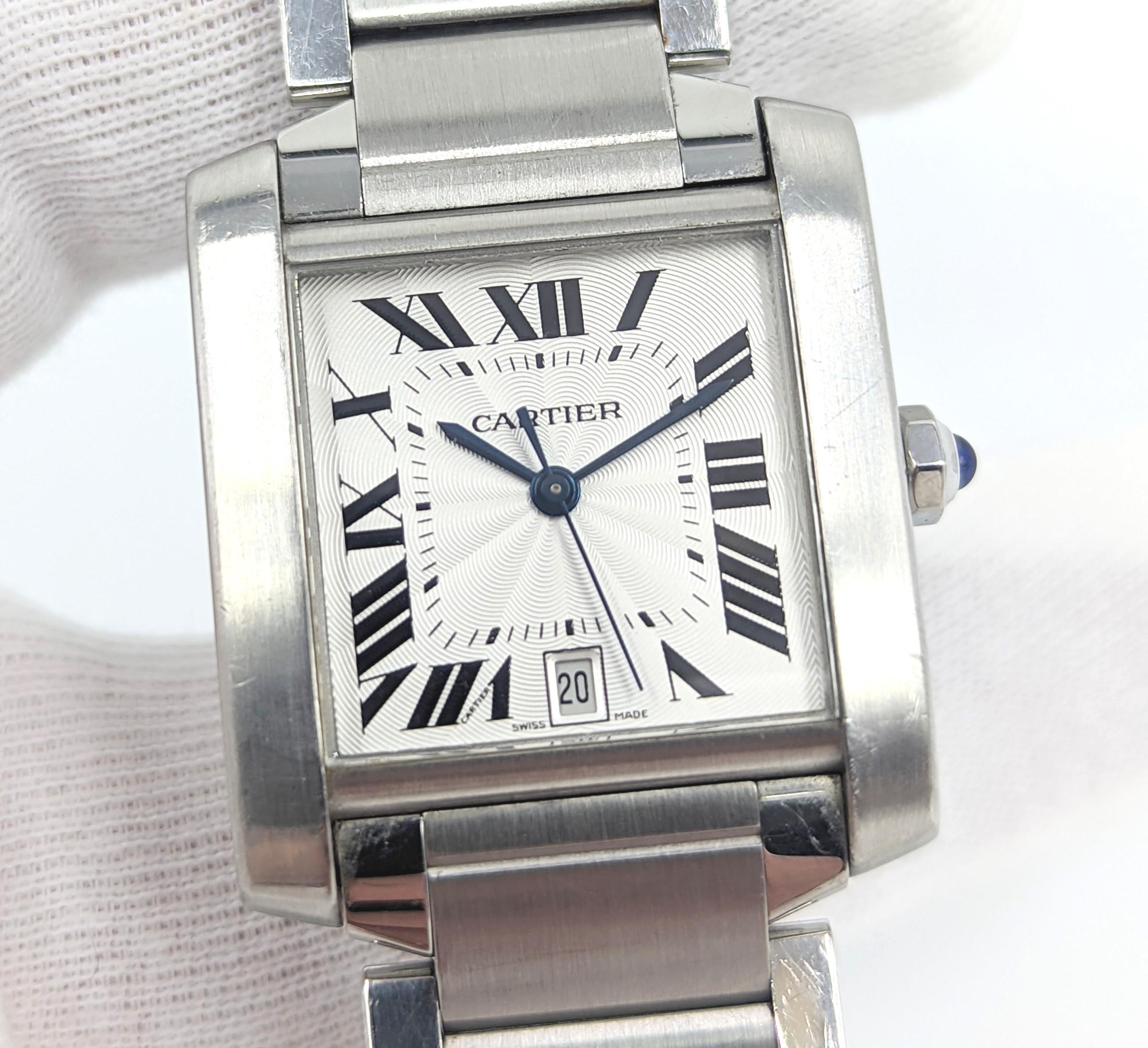 Eine Cartier Tank Francaise Armbanduhr mittlerer Größe (32 mm) aus Edelstahl (Ref.2302). Das in der Schweiz hergestellte Uhrwerk hat einen automatischen Aufzug. Das Zifferblatt ist silbern mit schwarzen römischen Ziffern und einer Datumsanzeige bei