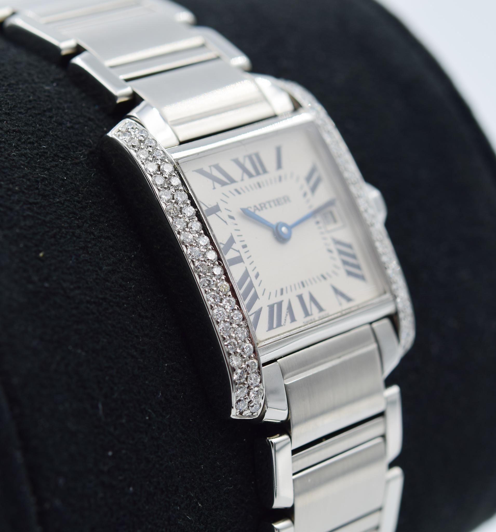 This Cartier Tank Francaise was recently traded in to our store and is in good condition with some normal indications of wear. This watch has a diamond aftermarket modification for the bezel down each side of the case. There are scratches on the