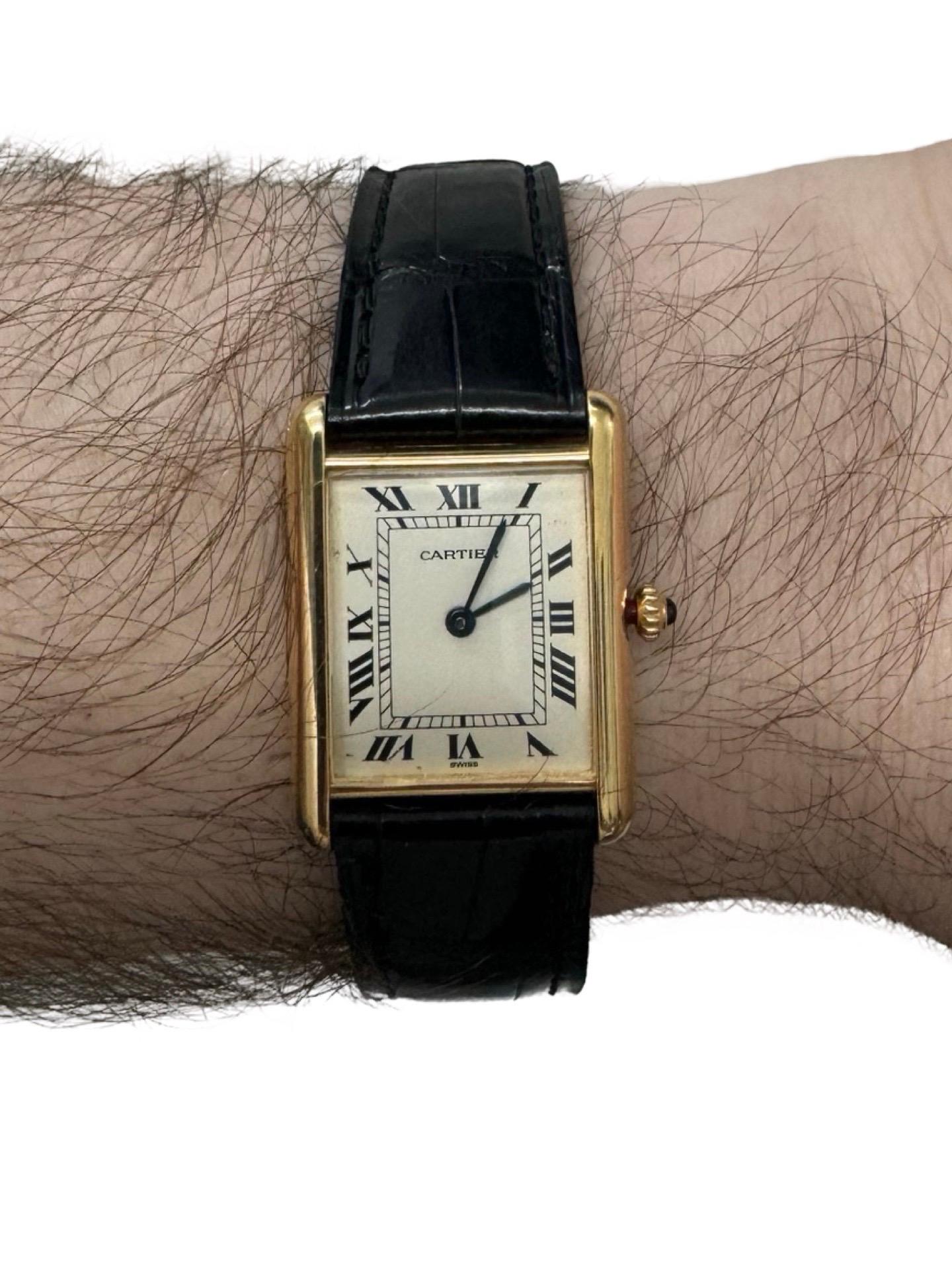 Experience timeless luxury with this Cartier Tank Louis in 18k solid gold, featuring a classic rectangular case, iconic Roman numeral dial, and blued steel hands. The watch is enhanced with a signature blue sapphire cabochon crown and paired with a