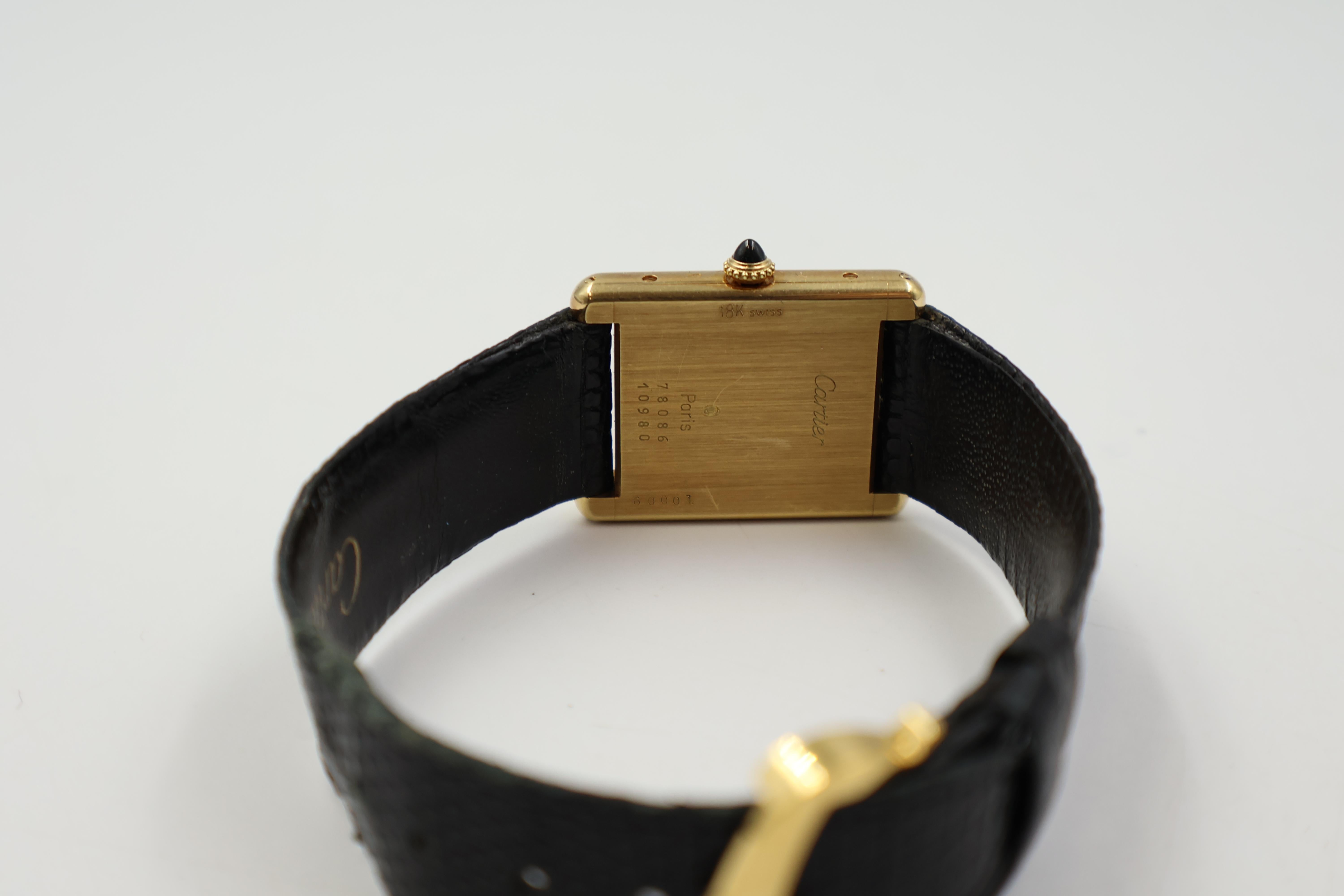 Cartier Tank Louis 80786 Herrenuhr.
Gehäuse und Lünette aus 18 Karat.
Weißes Zifferblatt mit blauen Cartier-Zeigern und schwarzen römischen Ziffern.
Manuelles Aufziehen.
Gehäusegröße: 23 mm x 30 mm
Zweiteiliges schwarzes Cartier-Lederarmband mit