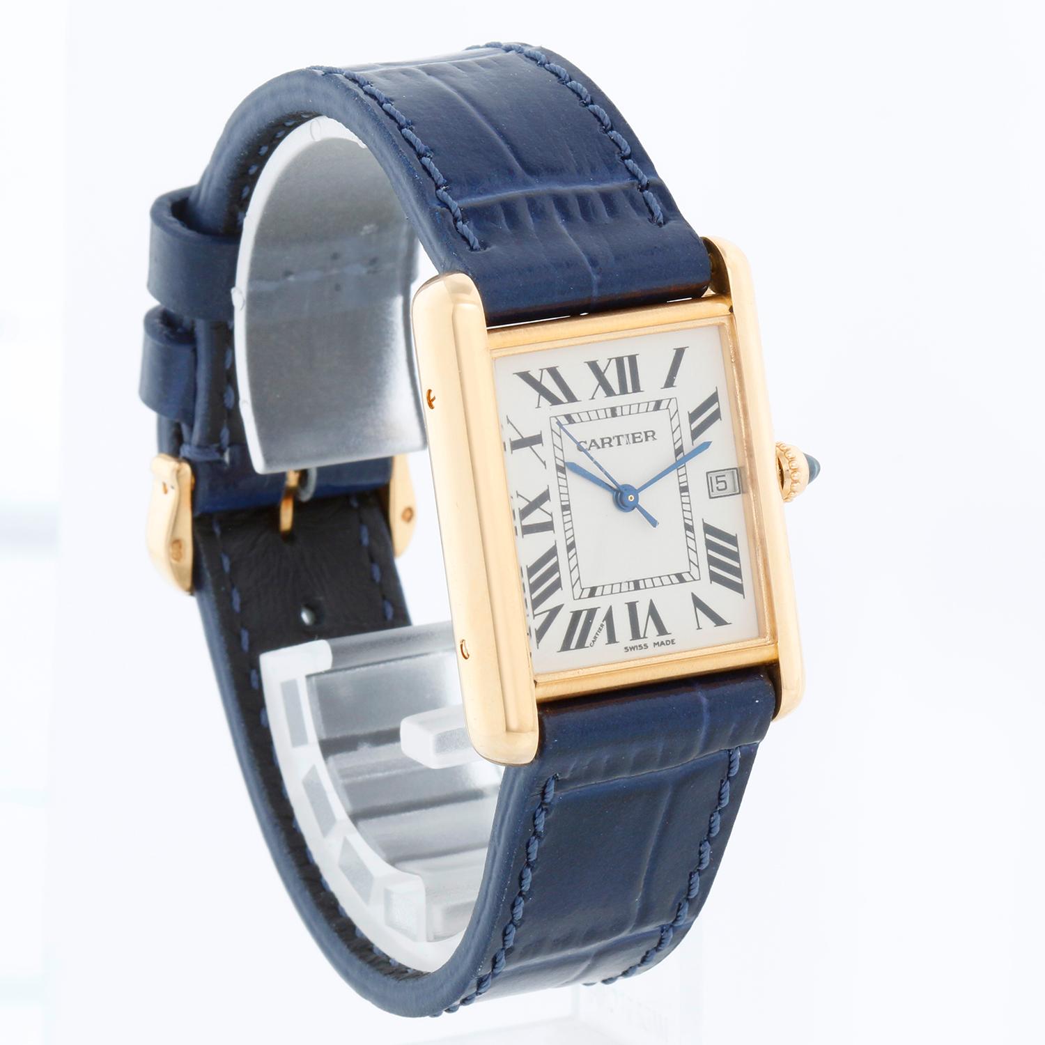 Montre unisexe en or jaune 18K Cartier Tank Louis W1529756 2441 - Quartz. Or jaune 18K ( 26 x 34 mm ). Cadran plat ivoire avec chiffres romains ; date à 3 heures. Bracelet bleu avec boucle ardillon en or de Cartier. D'occasion avec boîte