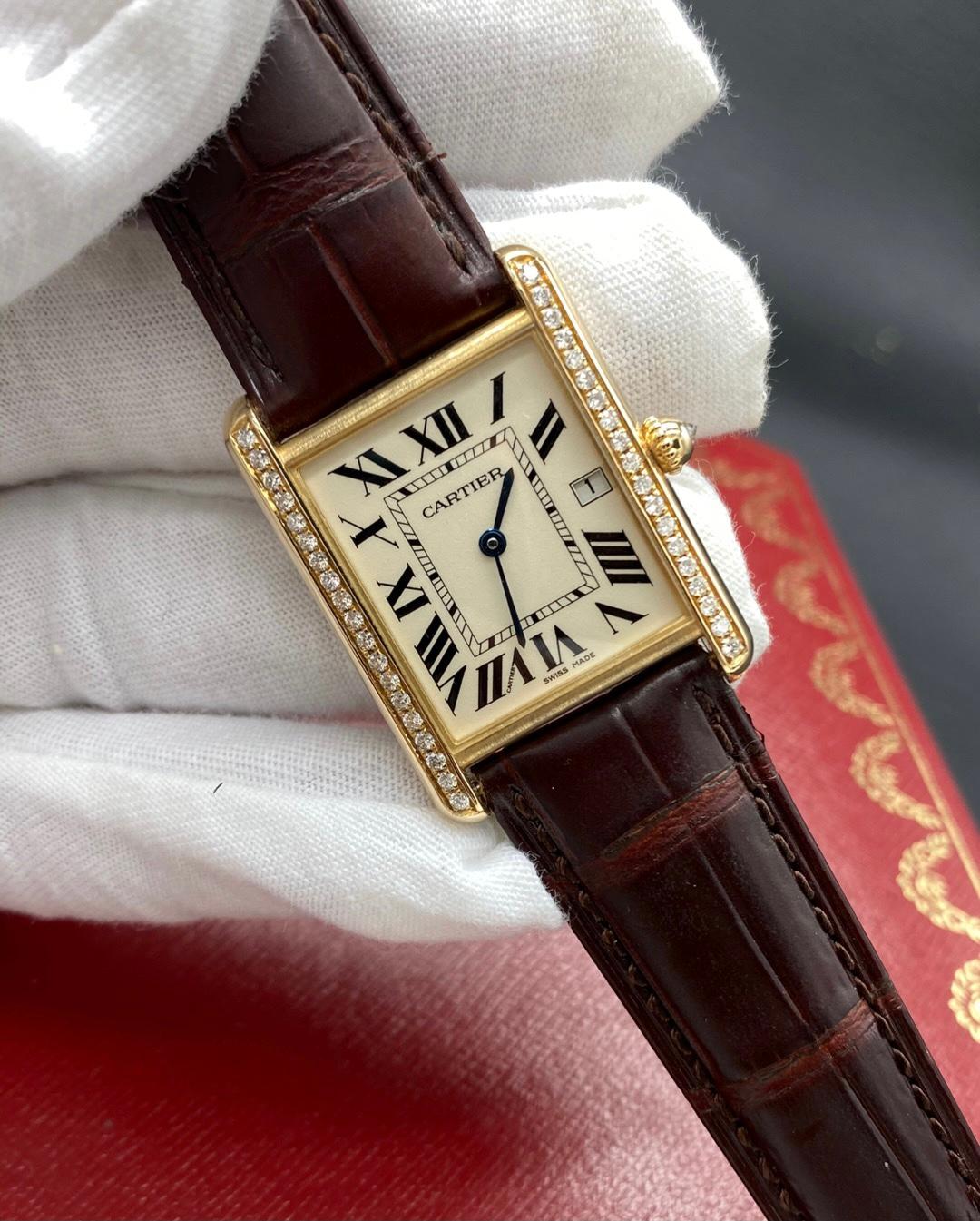 18K yellow gold case, 18K yellow gold circular-grained crown set with a diamond, mineral crystal, silver-grained dial, Roman numerals, sword-shaped blued-steel hands, alligator strap with 18K gold ardillon buckle, Cartier calibre 688 quartz