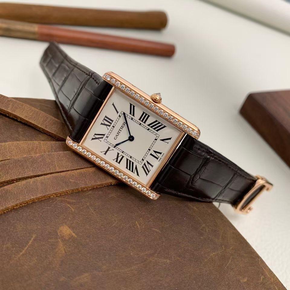 Cartier Tank Louis Gents, Model # WT200005. 18kt rose gold rectangular shape 40.40x32.5mm case. Silver-colored dial, with black Roman numeral hour markers and sword-shaped blue hour and minute hands. 18kt rose gold bezel set with round cut diamonds.