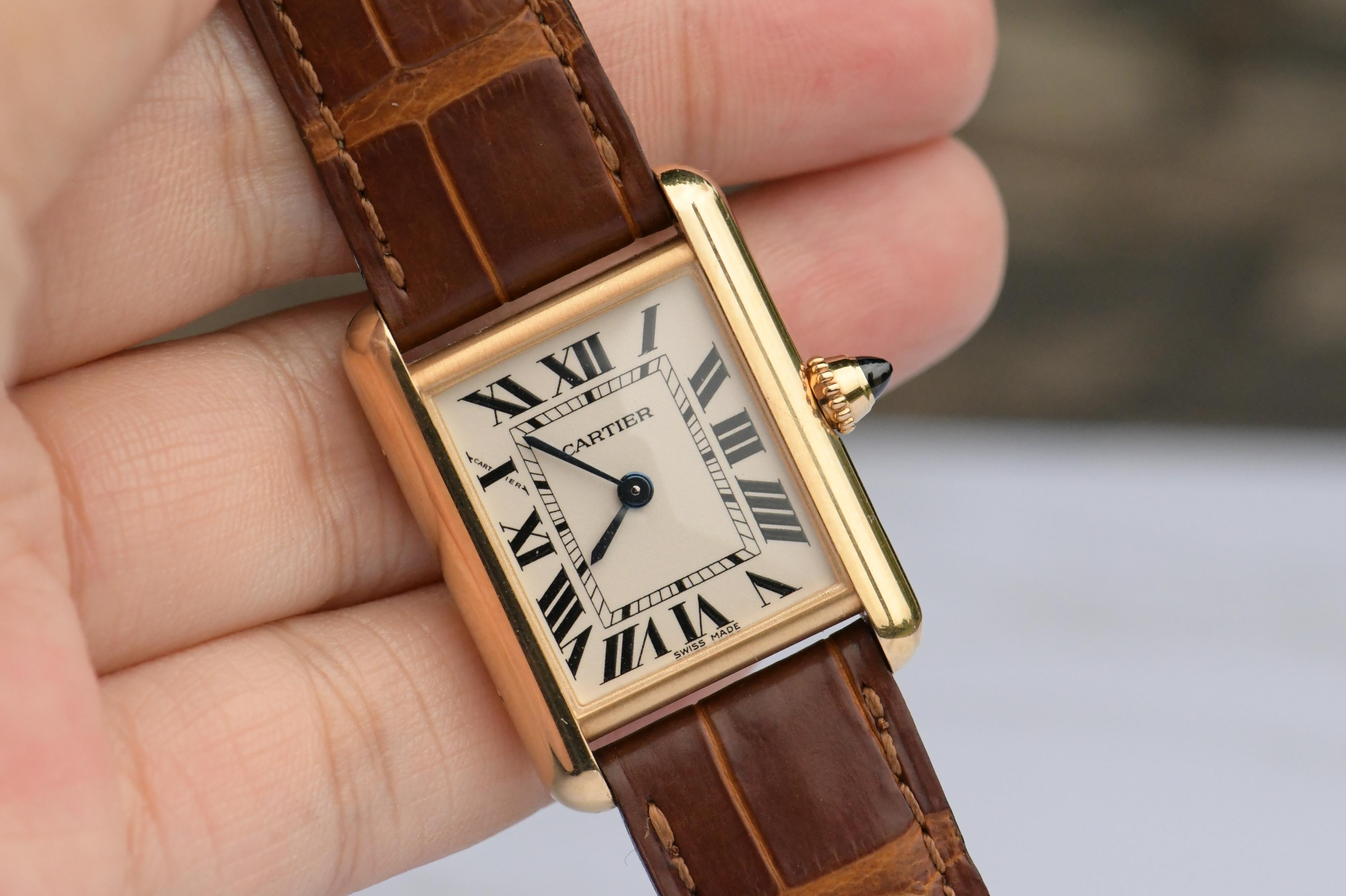 Brand: Cartier
Model: Tank Louis 
Age: 2010
Gender: Ladies/Unisex
Complete With: Dandelion Antiques Presentation Box
Dial: White Roman
Case Dimensions: 29.5 mm x 22 mm, thickness: 6.35 mm
Glass: Sapphire Crystal
Case Material: 18K Yellow Gold
Strap