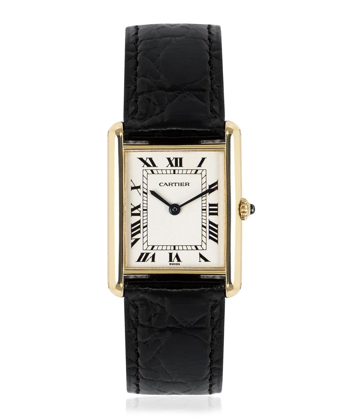 A 23 mm Tank Louis in yellow gold by Cartier. Features a silver dial with Roman numerals, sword-shaped hands in blued steel and a secret Cartier signature at V of VII. The crown is set with a single sapphire cabochon.

An original black leather