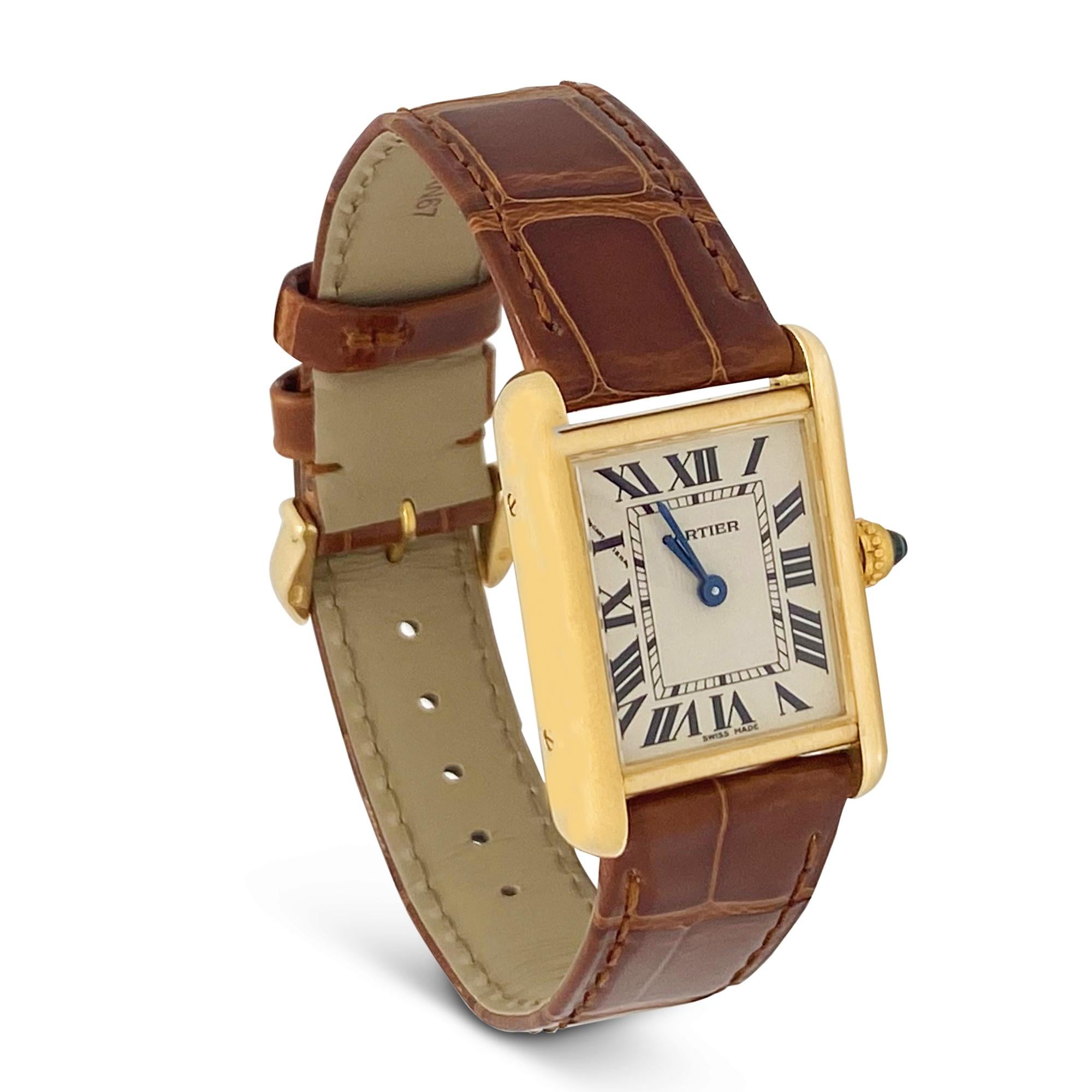 Authentic Cartier Tank Louis watch crafted in 18 karat yellow gold.  22mm x 29mm 18 karat yellow gold case, off-white dial, blued steel sword shaped hands and synthetic spinel crown.  Quartz movement. Brown alligator Cartier strap.  Watch is