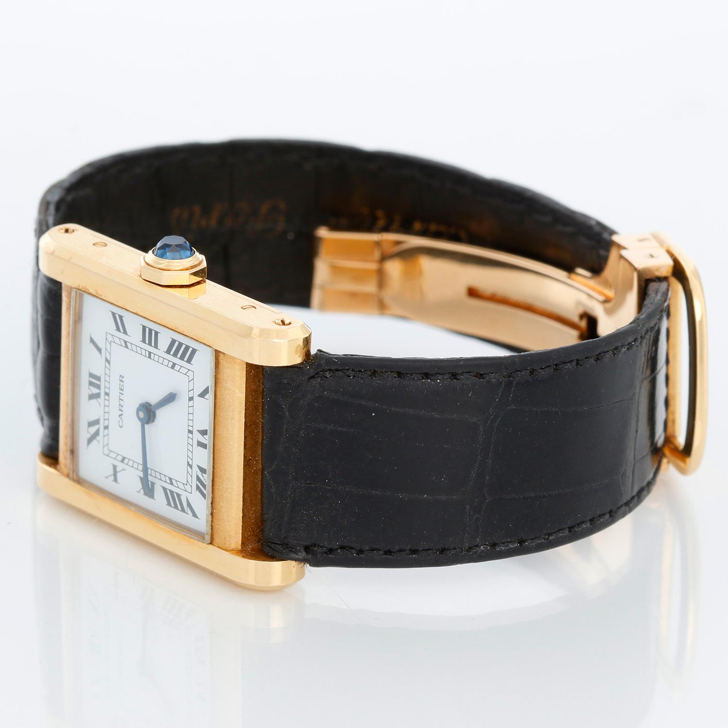 Cartier Tank Normale 18k Yellow Gold Men's Watch - Manual movement. 18k yellow gold case ( 23 mm x 30 mm ). White dial with black Roman numerals. Black strap band with 18k yellow gold Cartier buckle. Pre-owned with Cartier box, books and papers.