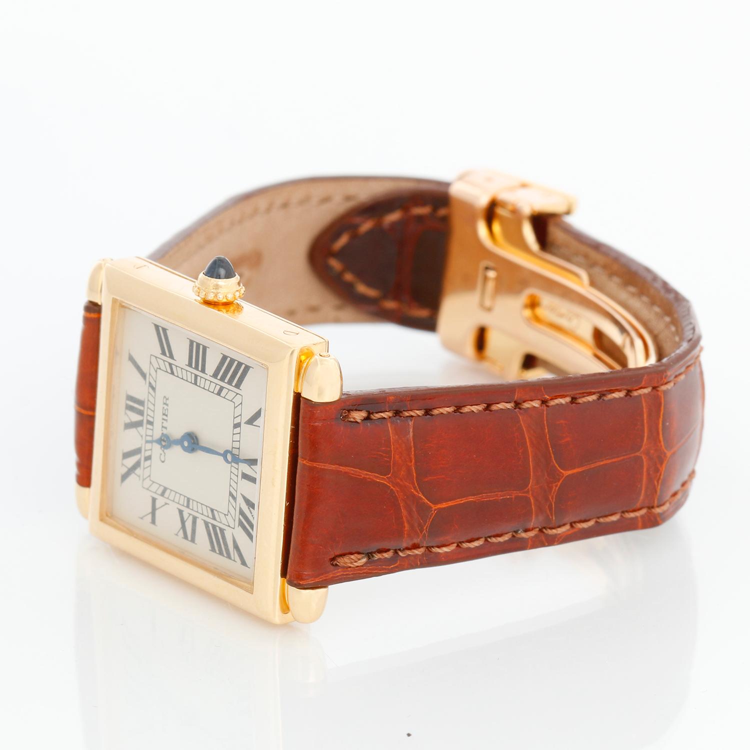 Cartier Tank Obus Men's or Ladies 18k Yellow Gold Watch - Quartz. 18k Yellow gold case (25mm x 32mm). Ivory dial with black Roman numerals. Brown Cartier bracelet with 18K yellow gold Cartier deployant clasp . Pre-owned with custom box.