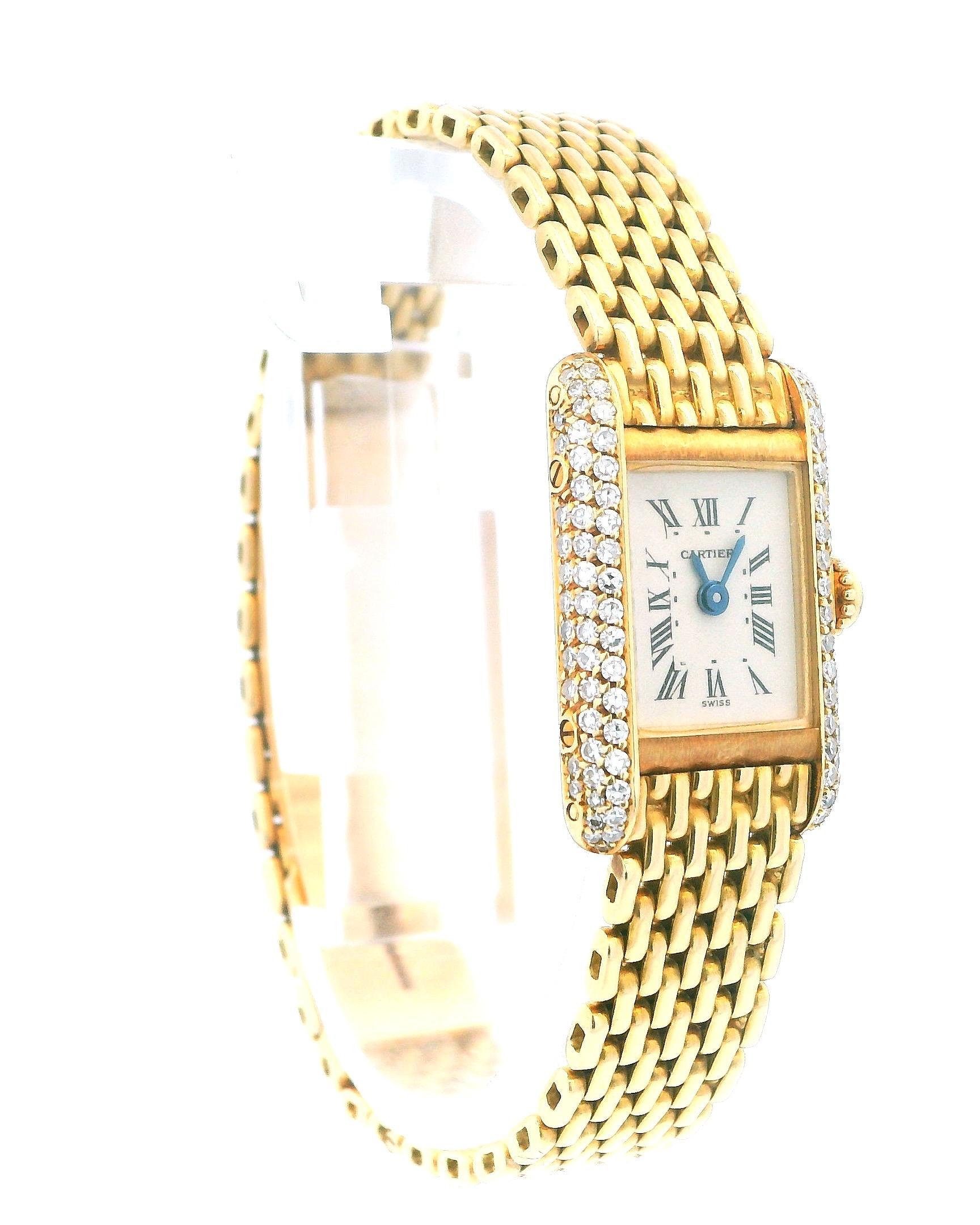 Cartier Tank Mini 0630 Ladies Watch. 15mm 18K yellow gold case with factory diamond bezel. Off-white dial with blue steel hands and roman numeral hour markers. Minute markers on the inner dial. 18K yellow gold with hidden fold over clasp. Will fit