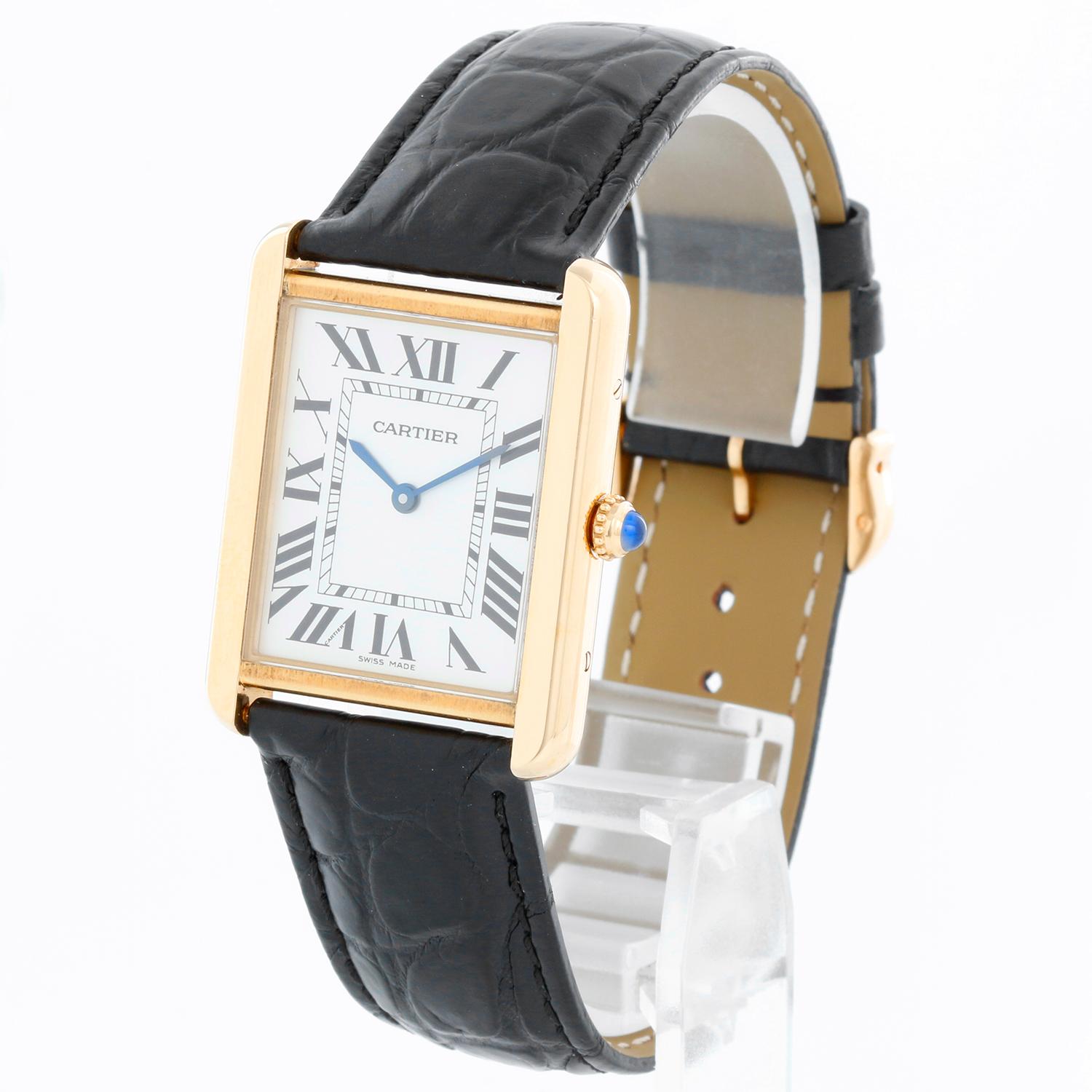 Cartier Tank Solo 18K Yellow Gold Men's Watch W1018855 2742 - Quartz movement. 18k yellow gold case with stainless steel back (27mm x 34mm). Silver colored dial with black Roman numerals. Black Cartier strap band with 18k yellow gold Cartier buckle.