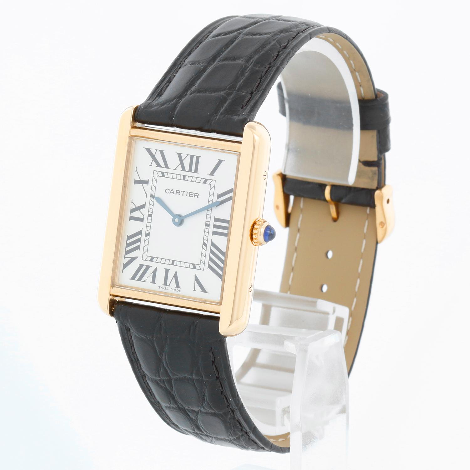Cartier Tank Solo 18K Yellow Gold Men's Watch W1018855 2742 - Quartz movement. 18k yellow gold case with stainless steel back (27mm x 34mm). Silver colored dial with black Roman numerals. Black Cartier strap band with 18k yellow gold Cartier buckle.