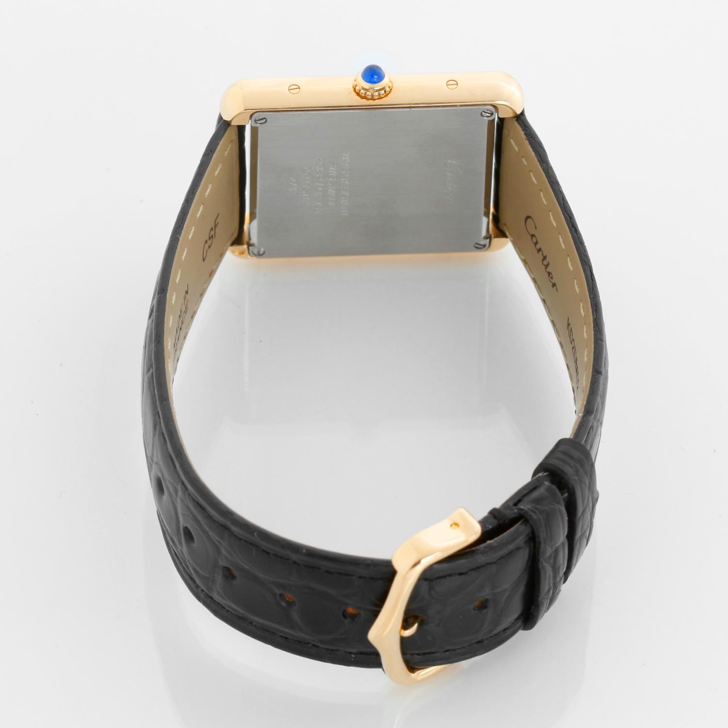 Cartier Tank Solo 18K Yellow Gold Men's Watch W1018855 2742 - Quartz movement. 18k yellow gold case with stainless steel back (27mm x 34mm). Silver colored dial with black Roman numerals. Black Cartier strap band with 18k yellow gold Cartier buckle.
