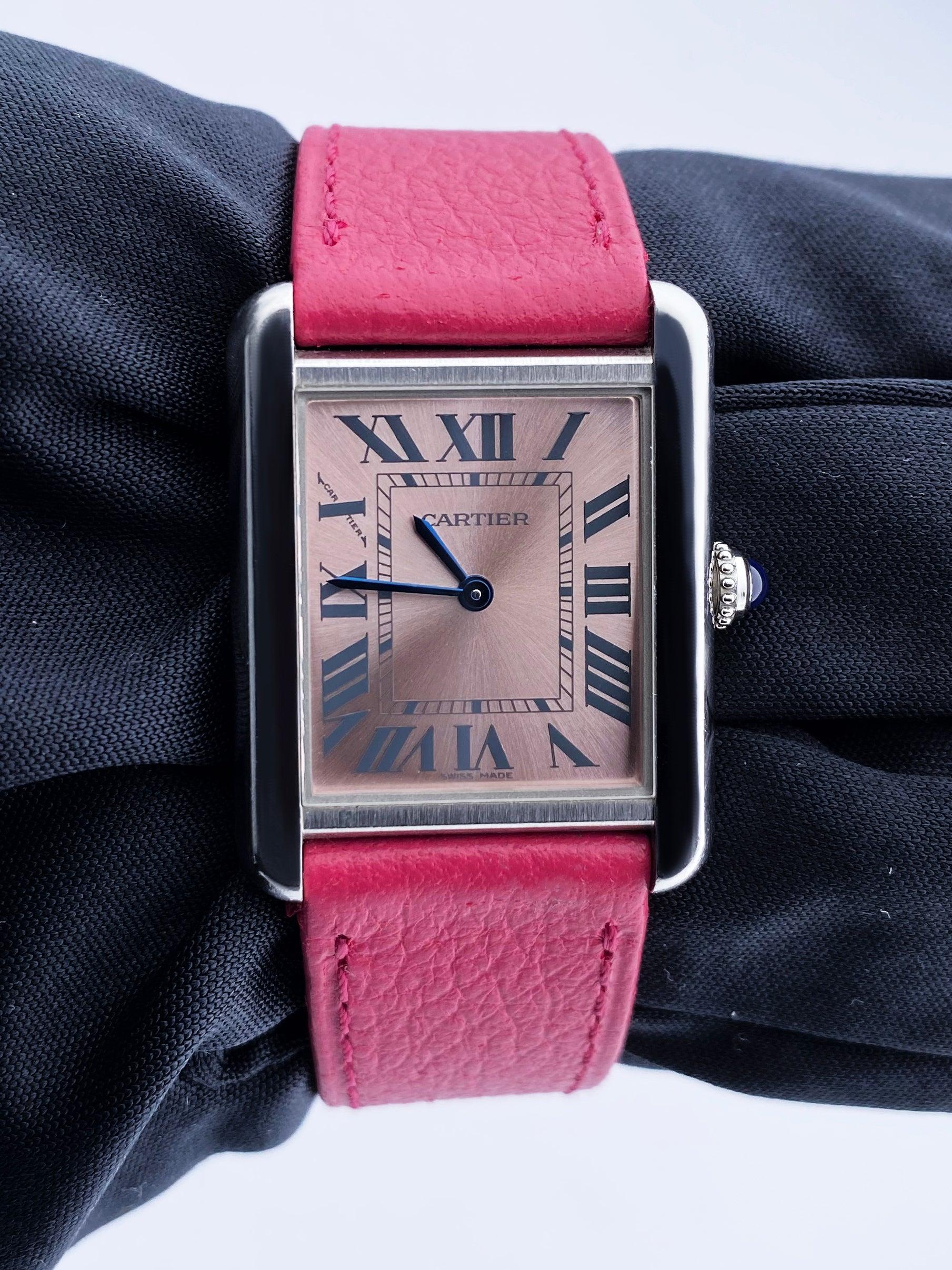 Cartier Tank Solo 3170 Ladies Watch. 24mm stainless steel case. Stainless steel stationary bezel. Pink dial with blue steel hands and Roman numeral hour markers. Minute markers on the inner dial. Pink leather strap with deployment clasp. Will fit up