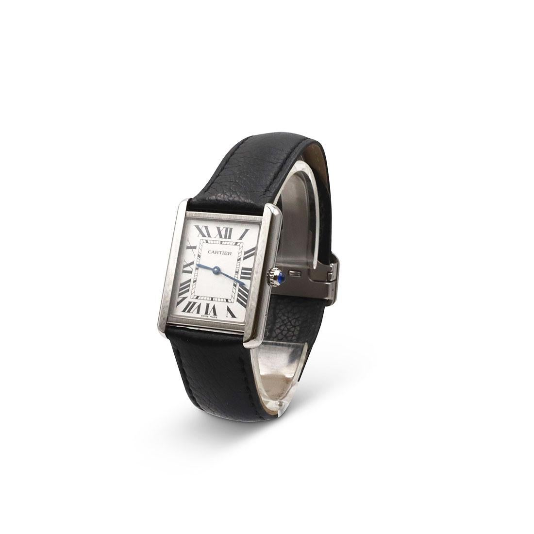 Authentic Cartier Tank Solo watch with steel case, beaded crown set with a synthetic cabochon-shaped spinel, silvered light opaline dial, Roman numeral hour markers, and blued-steel sword-shaped hands. 
The black grained calfskin leather strap shows