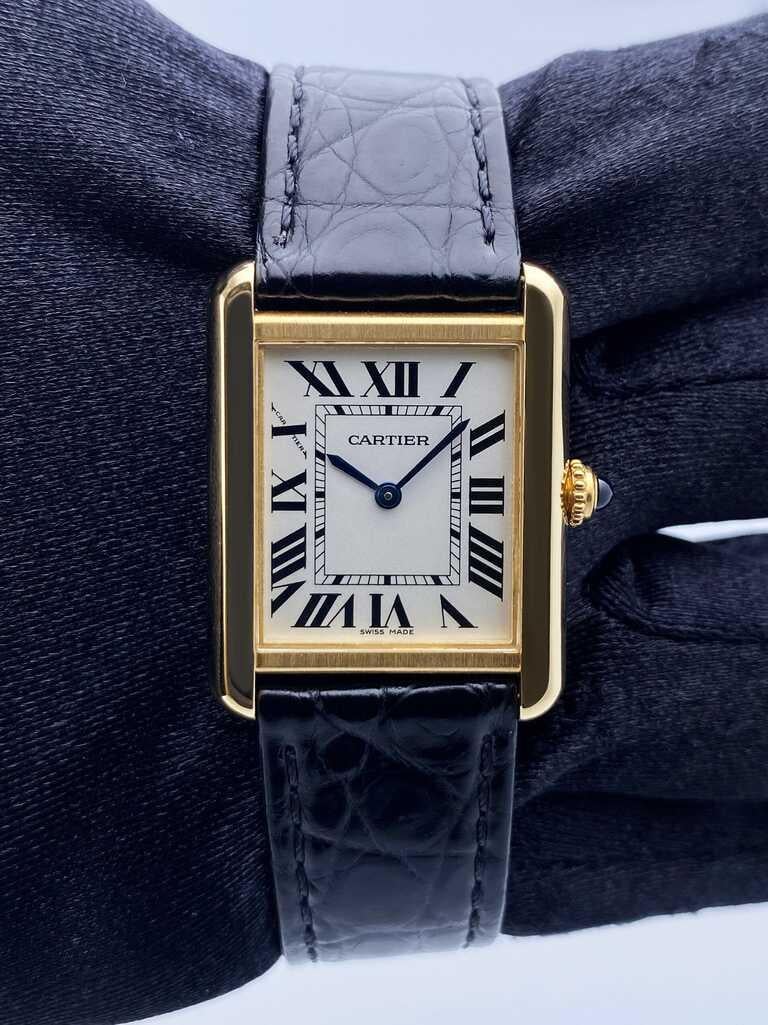 Cartier Tank Solo W5200002 / 3168 Ladies Watch.¬†24mm 18K¬†yellow gold¬†case. Sliver¬†dial with blue steel hands and Roman numeral hour markers. Minute markers on the inner dial. Black¬†leather strap¬†with 18K¬†yellow gold buckle. Will fit up to a