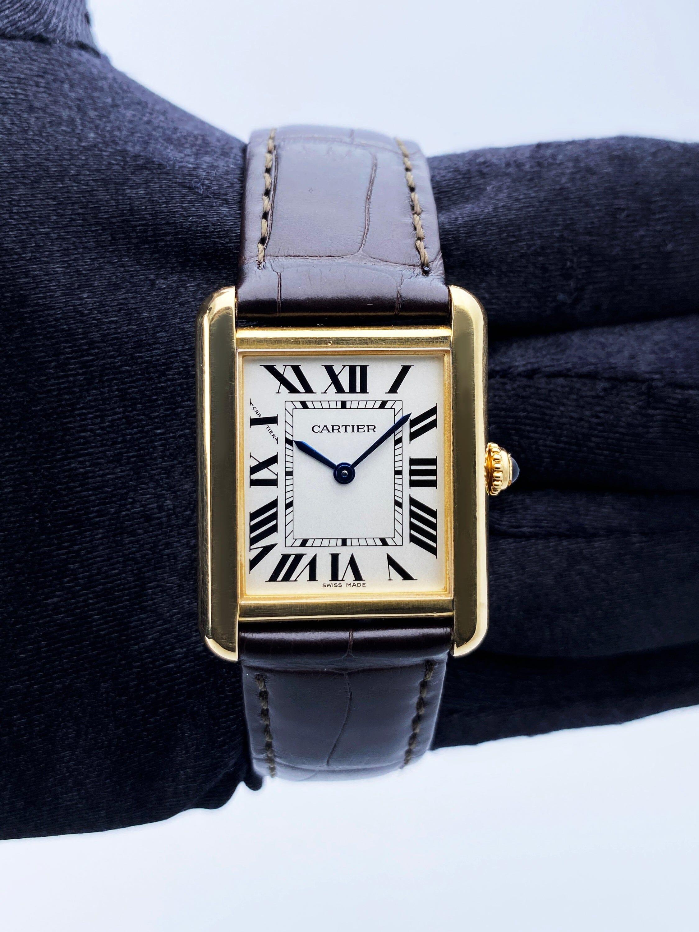 Cartier Tank Solo W5200002 / 3168 Ladies Watch. 24mm 18K yellow gold case. Sliver dial with blue steel hands and Roman numeral hour markers. Minute markers on the inner dial. Black leather strap with 18K yellow gold buckle. Will fit up to a 6-inch