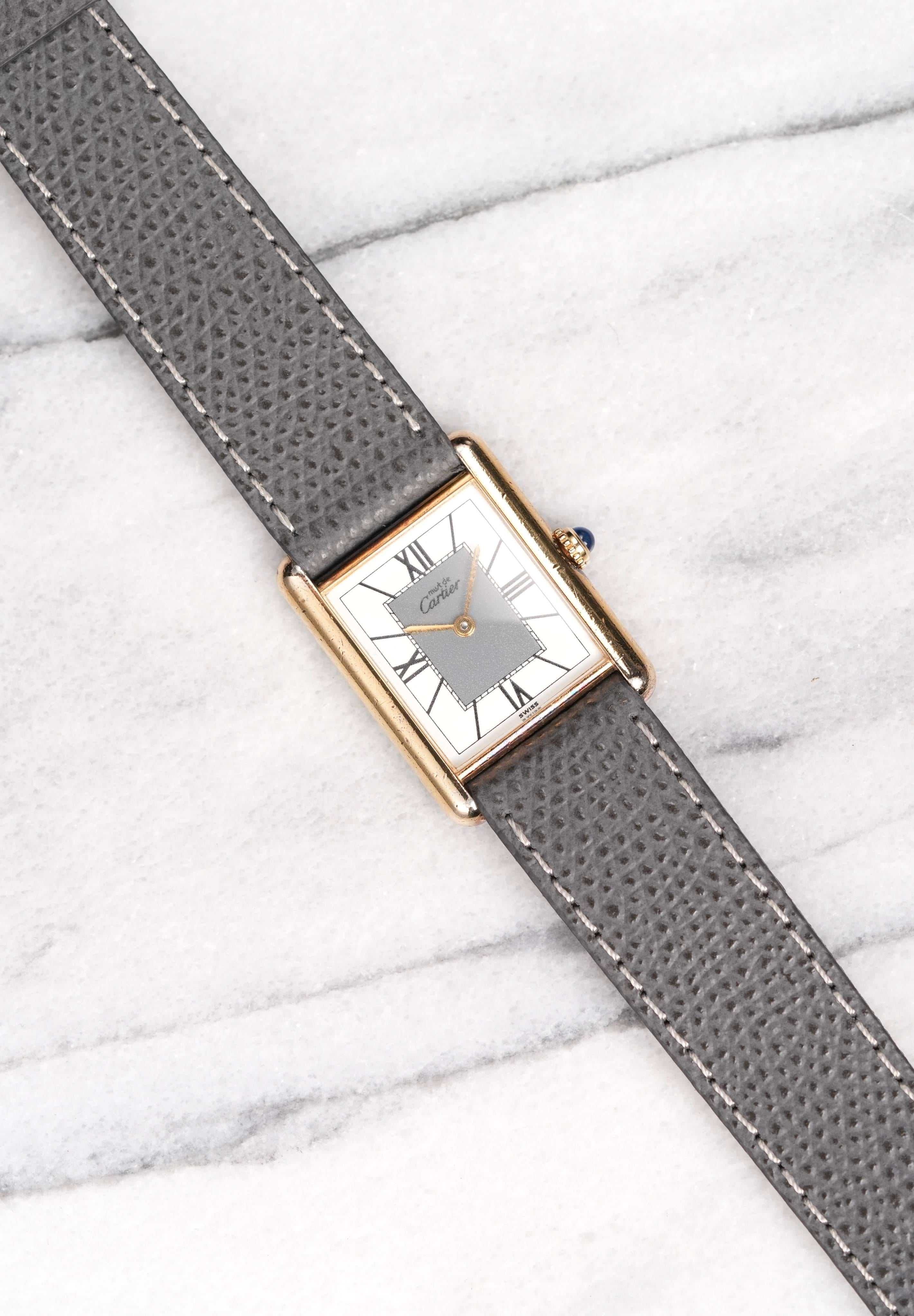 Hier ist eine alte Cartier Tank (Must de Cartier) Quarzuhr mit einem schönen grau-weißen zweifarbigen Zifferblatt aus den 1980er Jahren. Hält die Zeit gut ein und ist voll funktionsfähig. Die Abmessungen umfassen ein 23x30 mm großes Gehäuse und eine