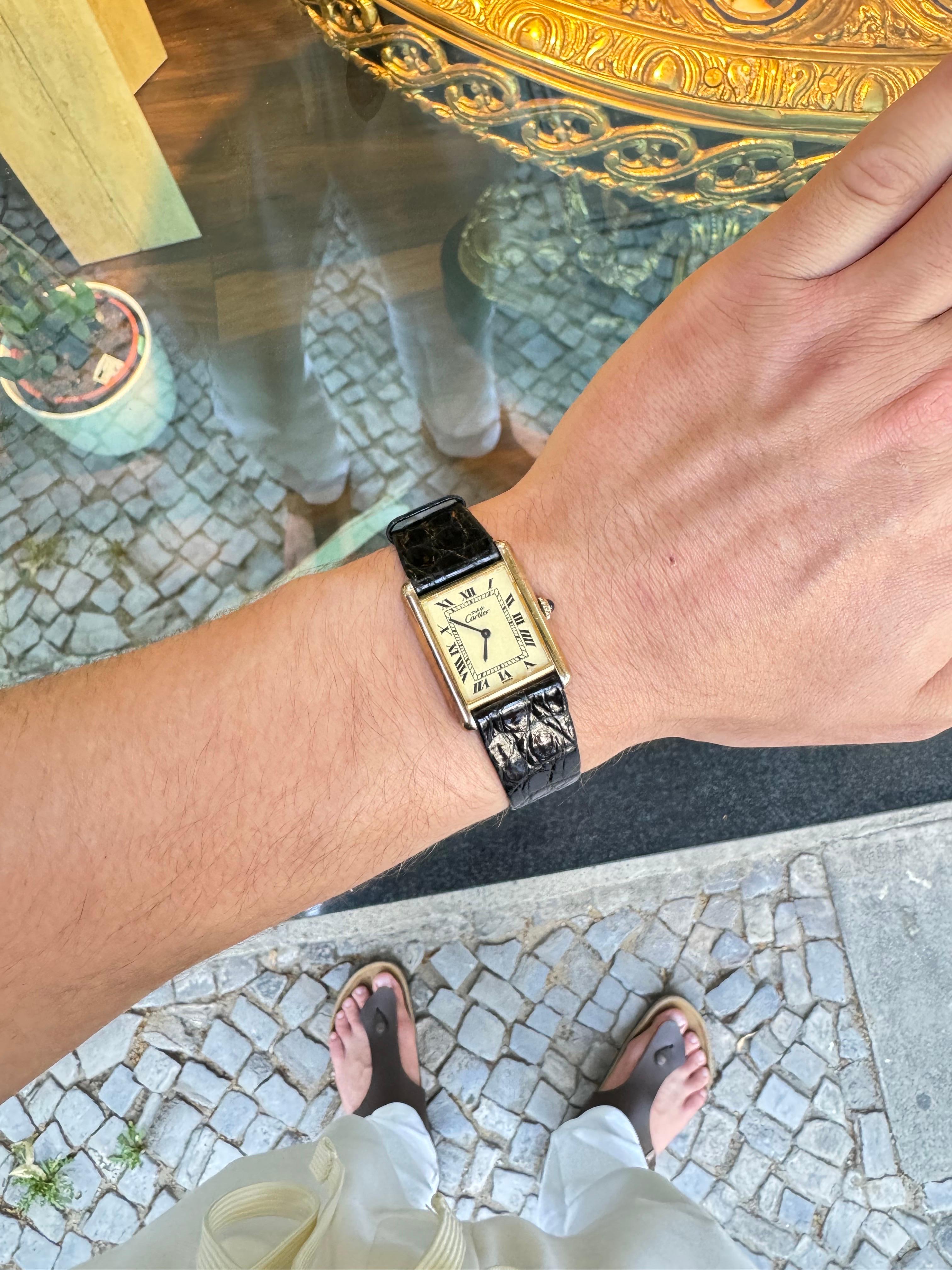 For sale is a majestic Cartier Tank Argent wristwatch, a symbol of timeless elegance and luxury. This exquisite timepiece features a solid 925 sterling silver case with 18K gold plating, exuding a sophisticated and classic appeal. The watch is
