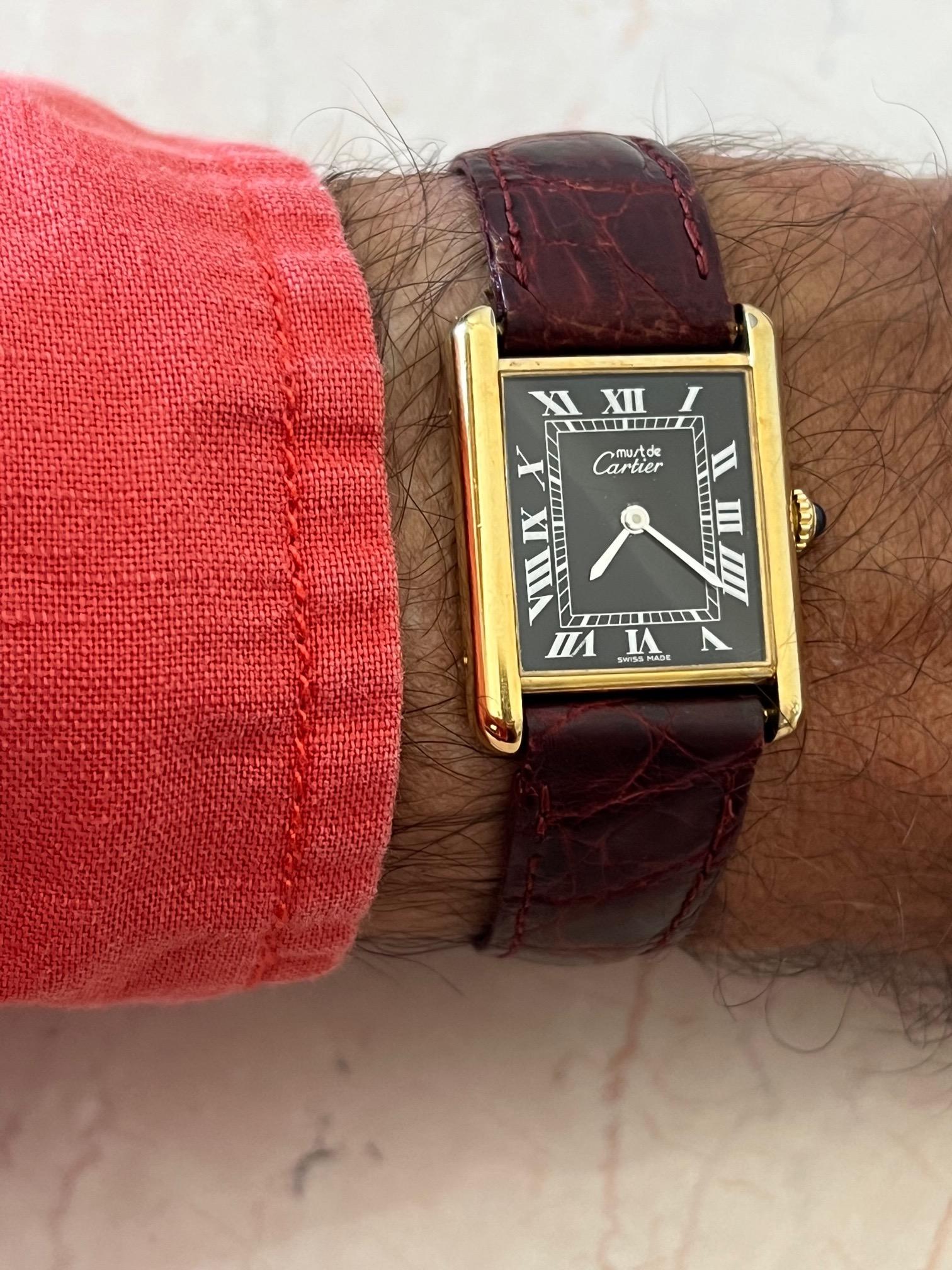 Une belle montre réservoir de Cartier datant des années 1980. Boîtier en or 925 avec mouvement manuel et couronne classique en cabochon de citrine. Comprend la pochette de service, la garantie, récemment révisée par Cartier.