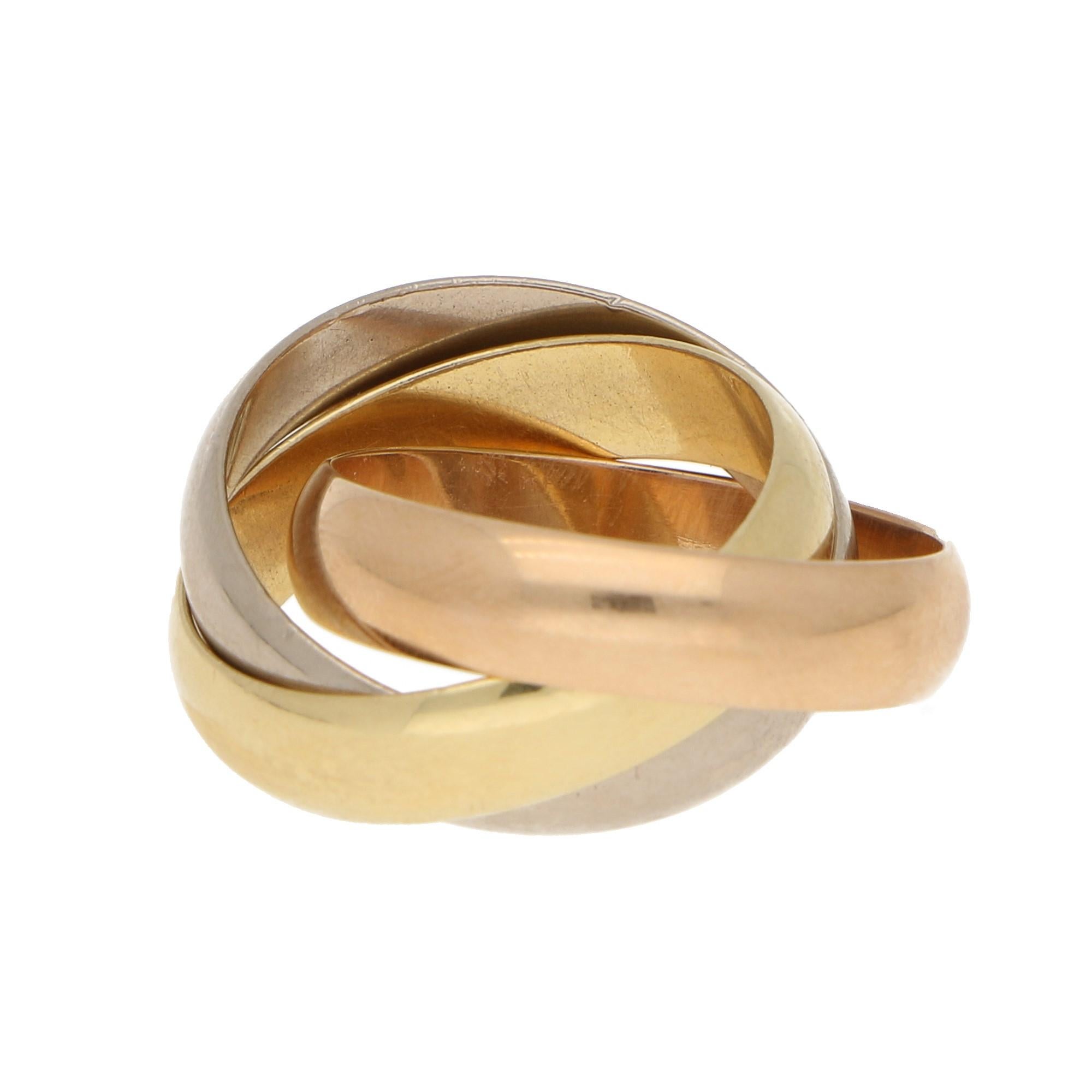 A classic from Cartier, this 3-band ring in 18-karat gold is composed of 1 yellow bands, 1 white band, and 1 rose band, the latter one engraved with “Cartier” on the outside. This ring is a US finger size 7-8. 
