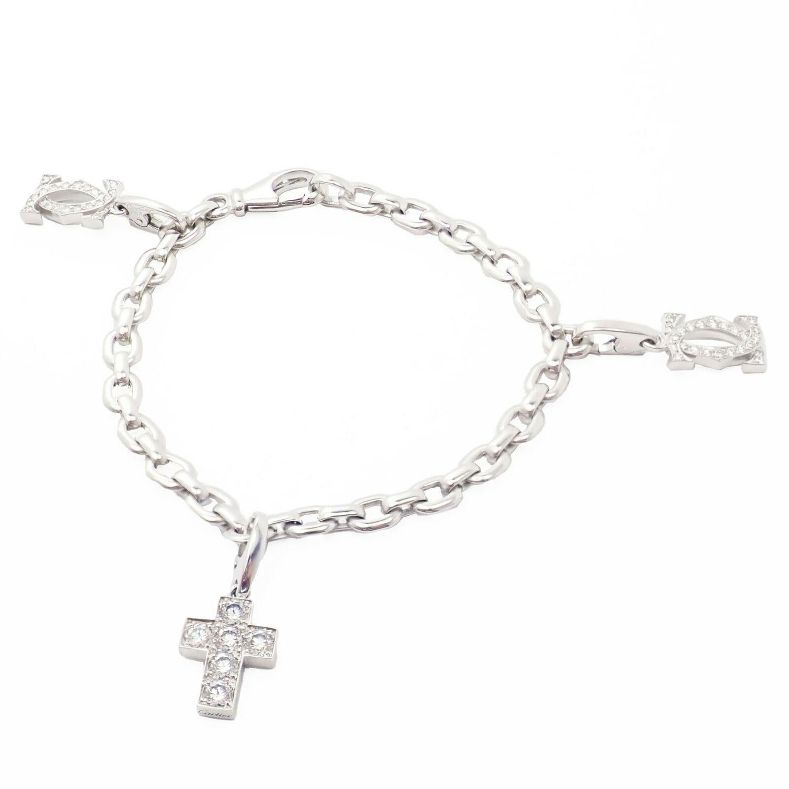 18k White Gold Diamond Three Charms Diamond Cross and two Double C Penelope Link Bracelet by Cartier.
With Round Brilliant Cut Diamonds Double C charms: 0.21ctw VVS Clarity/F Color (each)
Cross Charm: 6 Diamonds - 0.84ctw VVS Clarity/F Color
Each