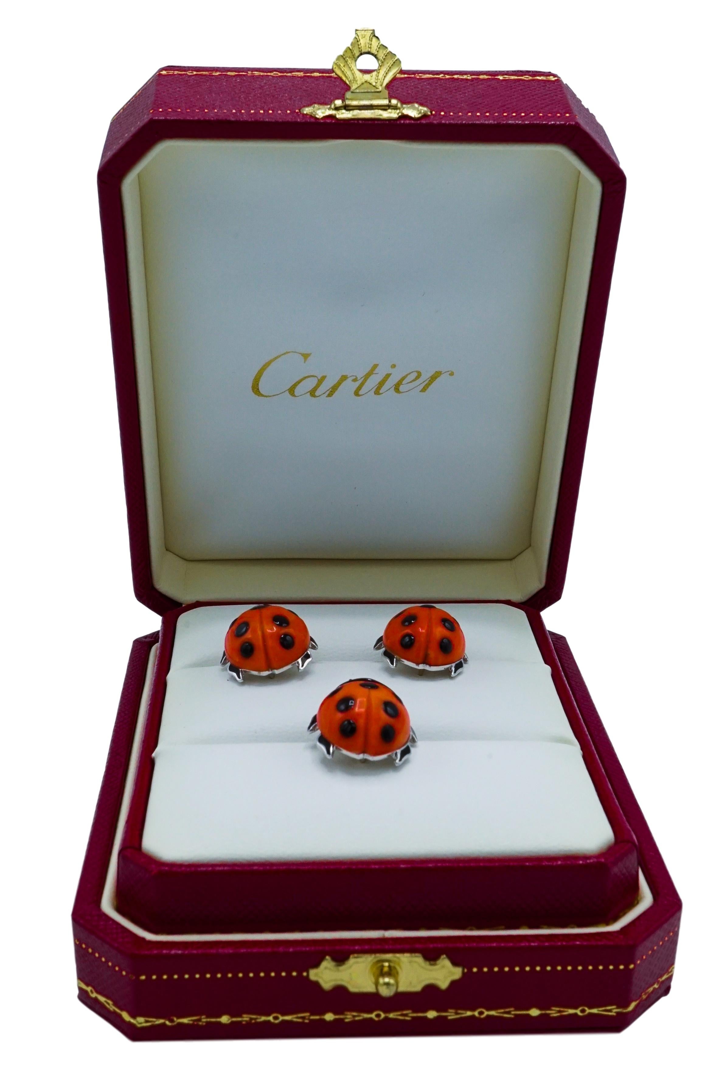 Designed as three ladybugs, the wings of carved coral highlighted with black enamel spots, the heads and legs applied with black enamel, one signed Cartier, two partially signed Cartier, numbered 631384, 631385, 640506, each with French assay and