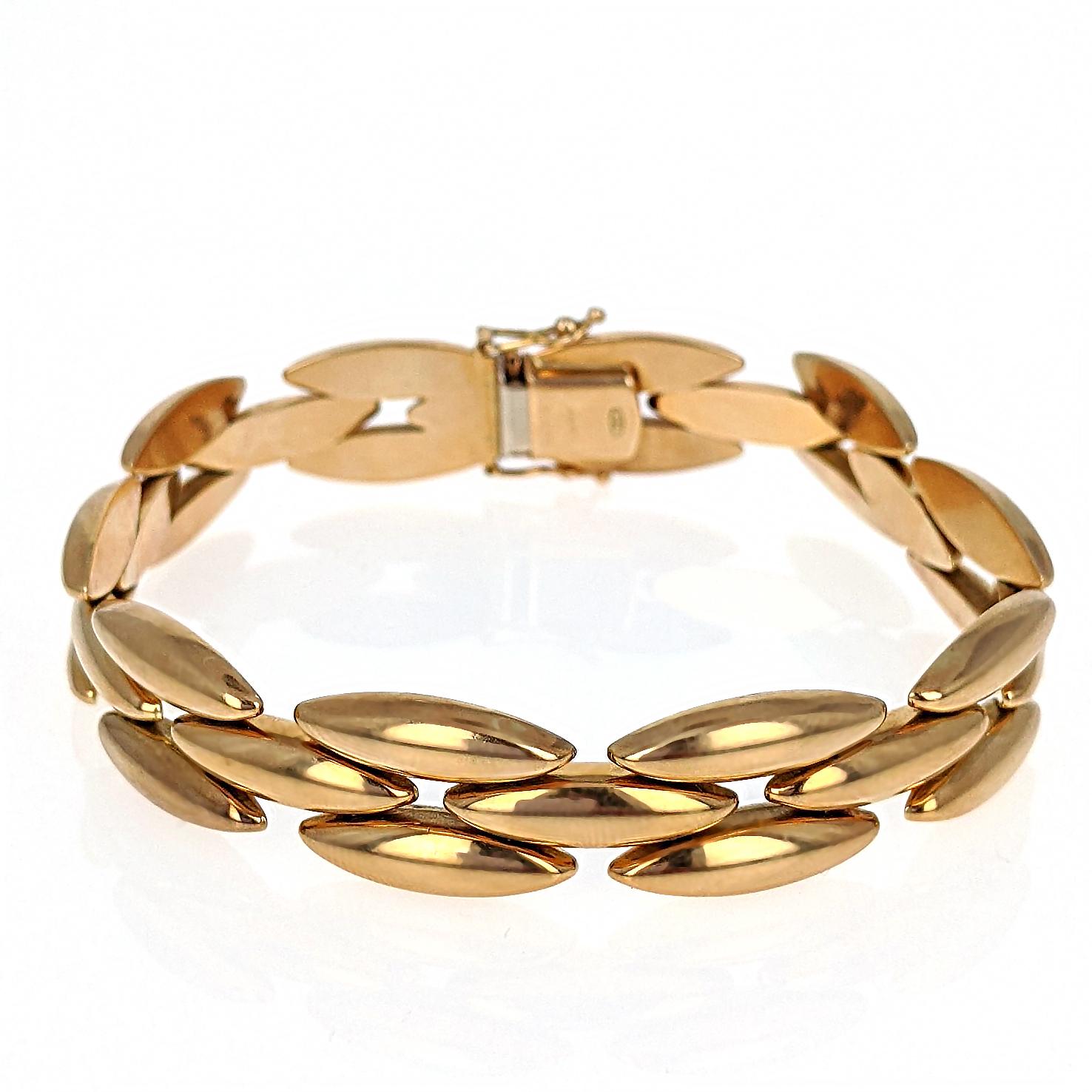 This Cartier link bracelet is designed as a modified tank bracelet with three rows of elongated oval gentiane rice links and is mounted in 18 karat yellow gold. It has a box clasp closure with two safety clasps. It is signed, numbered, with Italian