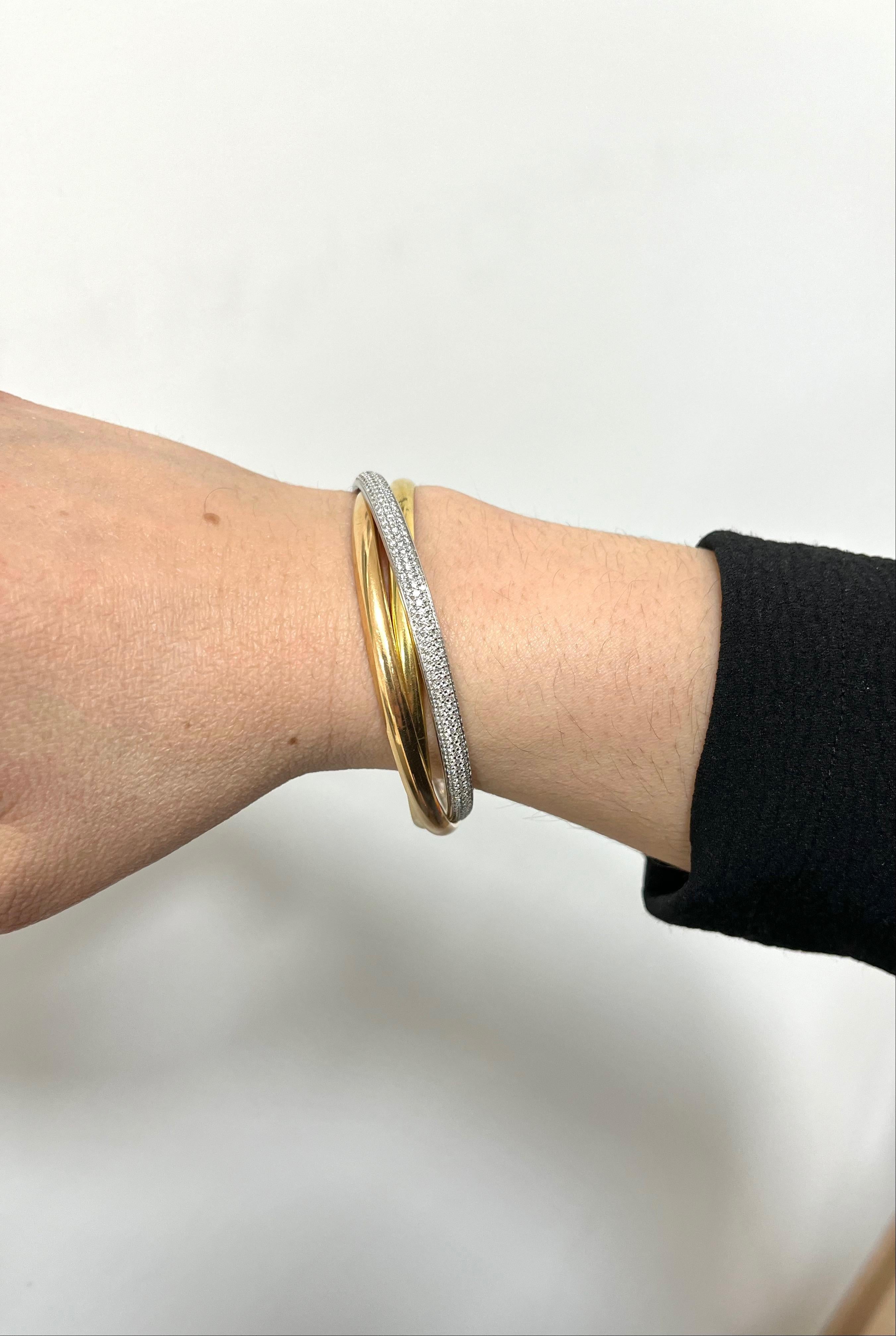 18 kt. three tone gold bangles with diamonds hand-made in France.
This iconic design is signed and numbered by Cartier.
This 18k three tone gold trinity bangle features one 18k white gold bangle embellished with 4.50 carat ca. of round-cut