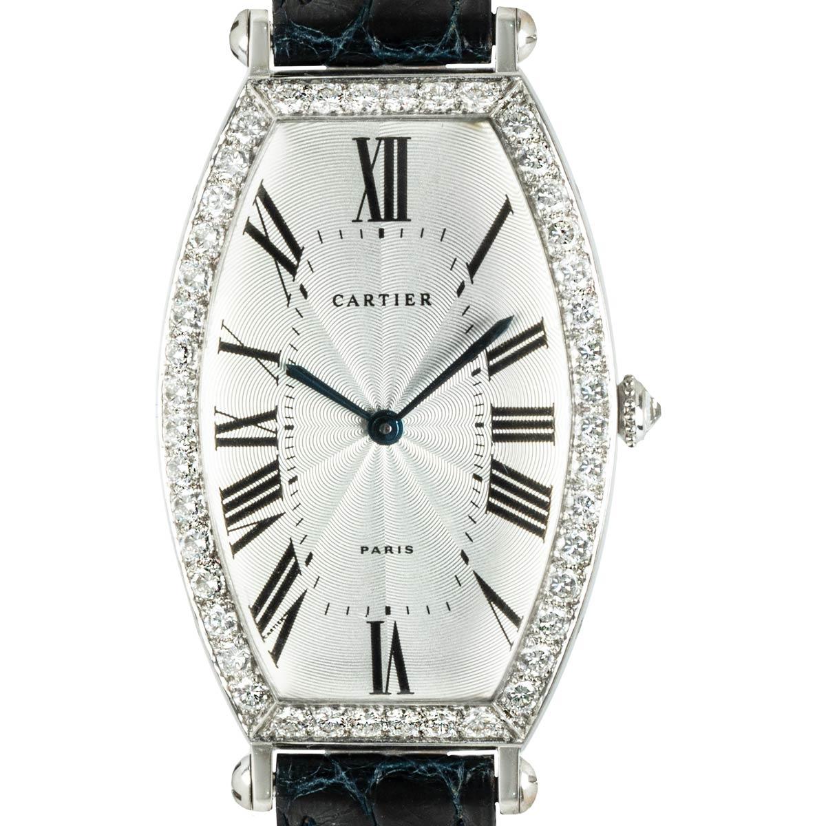 A striking men's Cartier Tonneau wristwatch crafted in white gold. Featuring a silver guilloche dial with roman numerals, blued steel sword shaped hands and a secret Cartier signature at VII. Complementing the dial is a fixed white gold bezel set