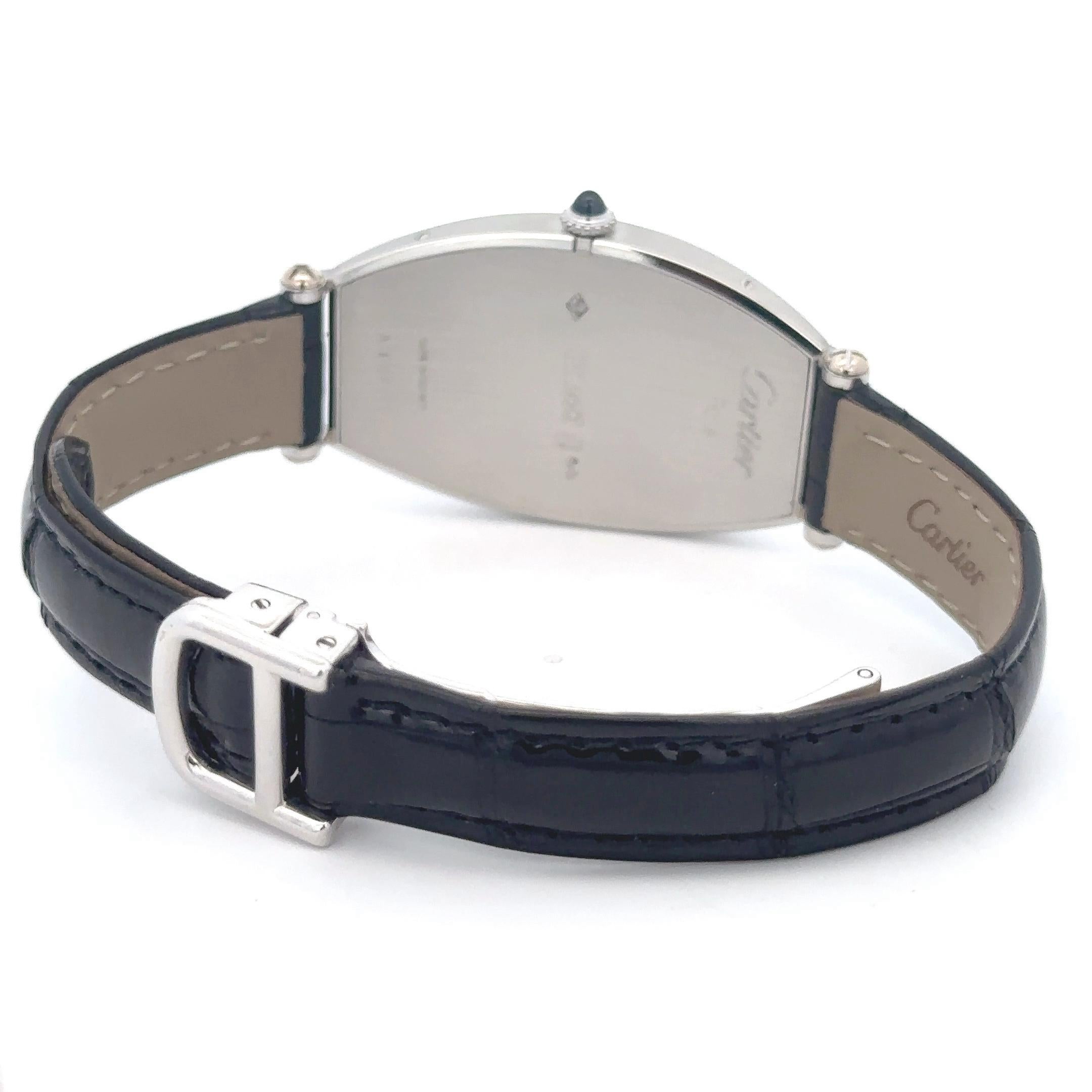 Introducing the Cartier Tonneau  Platinum Silver Dial Men's Watch a masterpiece of elegance. This manual-winding watch features a unique platinum tonneau-shaped case (26.0 x 39.0 mm) and an octagonal crown with a blue spinel cabochon. The smooth