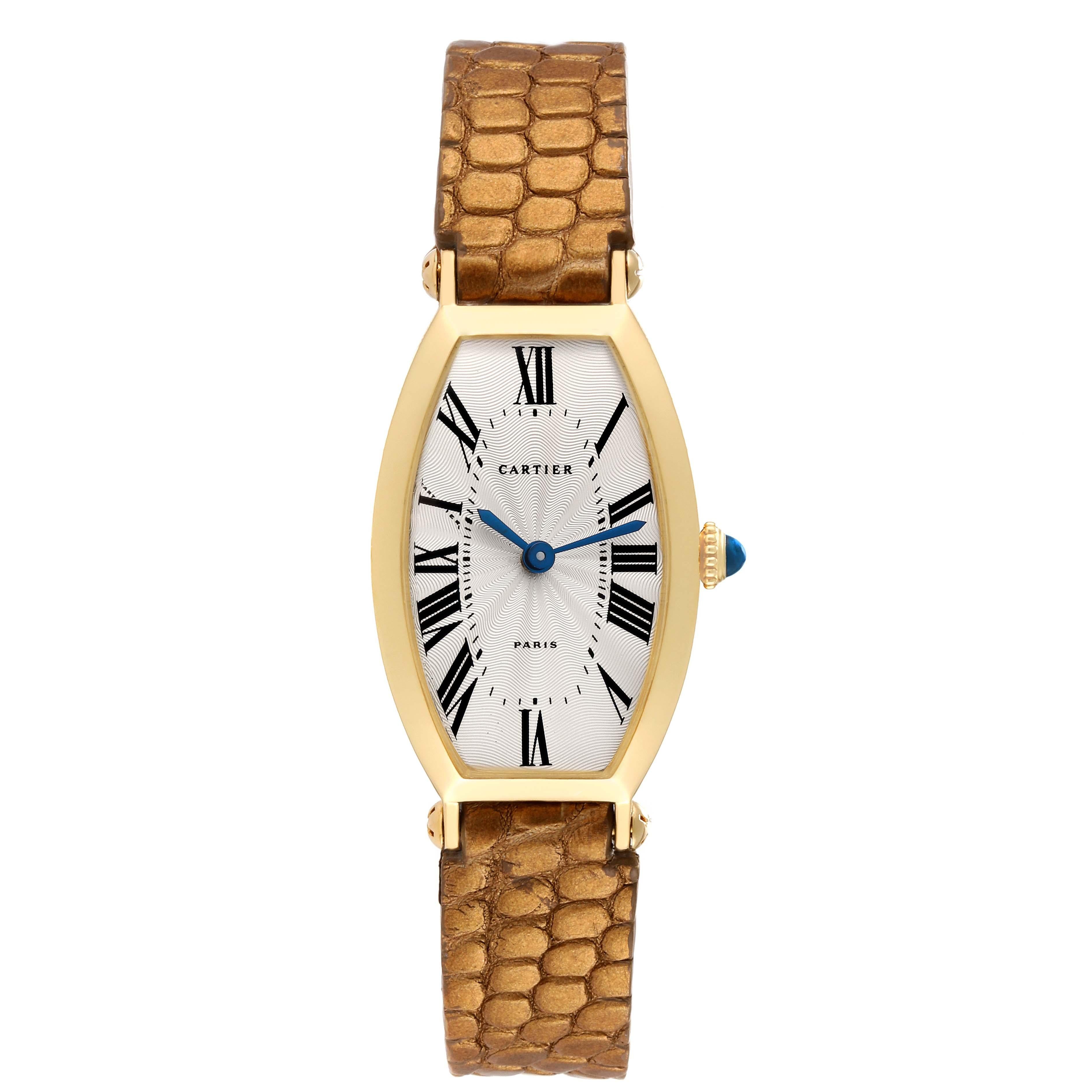 Cartier Tonneau Paris Yellow Gold Silver Dial Ladies Watch. Manual winding movement. 18K yellow gold tonneau shape case 32.0 x 21.0 mm. Circular grained crown set with the blue spinel cabochon. 18K yellow gold smooth bezel. Scratch resistant
