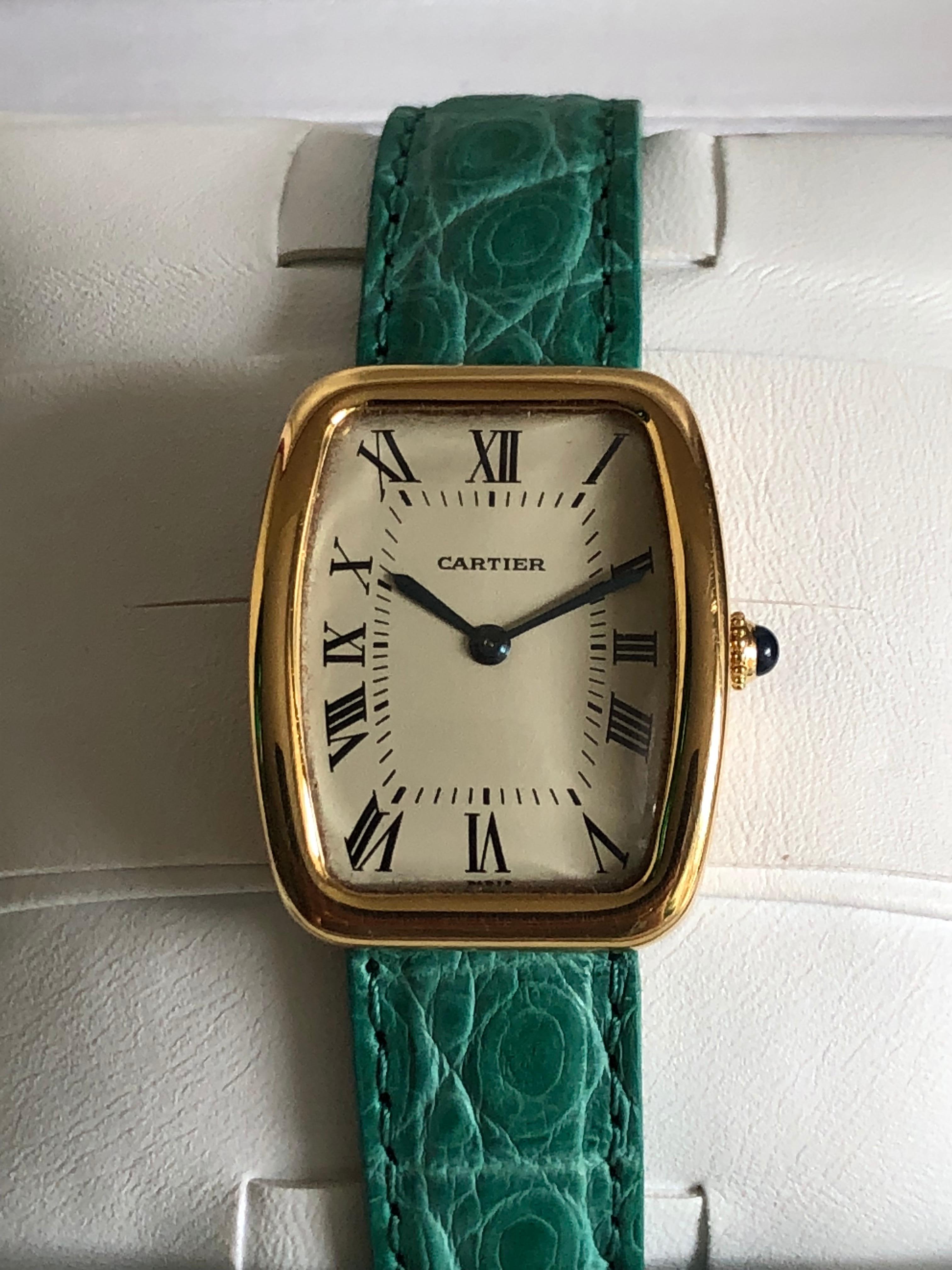 Watch Tonneau-Tortue by Cartier yellow gold - sapphire crowned. Buckle is gold plated.

Signed, numbered and stamped.

Mechanical working movement. Bracelet is new and was made by a professional in green crocodile. Blister from last revising is