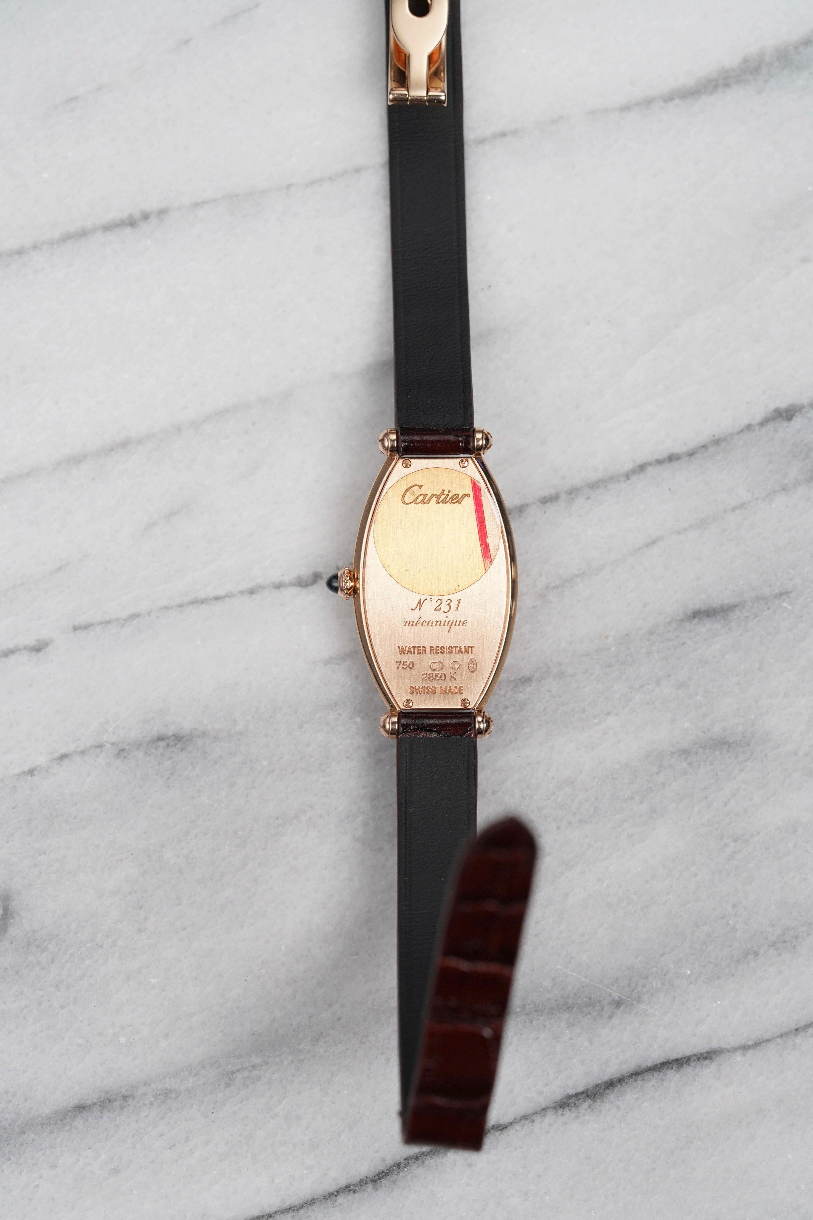 Voici une Cartier Tonneau référence 2850K en or rose 18 carats avec un cadran argenté guilloché à chiffres romains datant des années 1990. Les mesures comprennent un boîtier tonneau de 21 mm et une largeur de corne de 10 mm. Elle est montée sur un