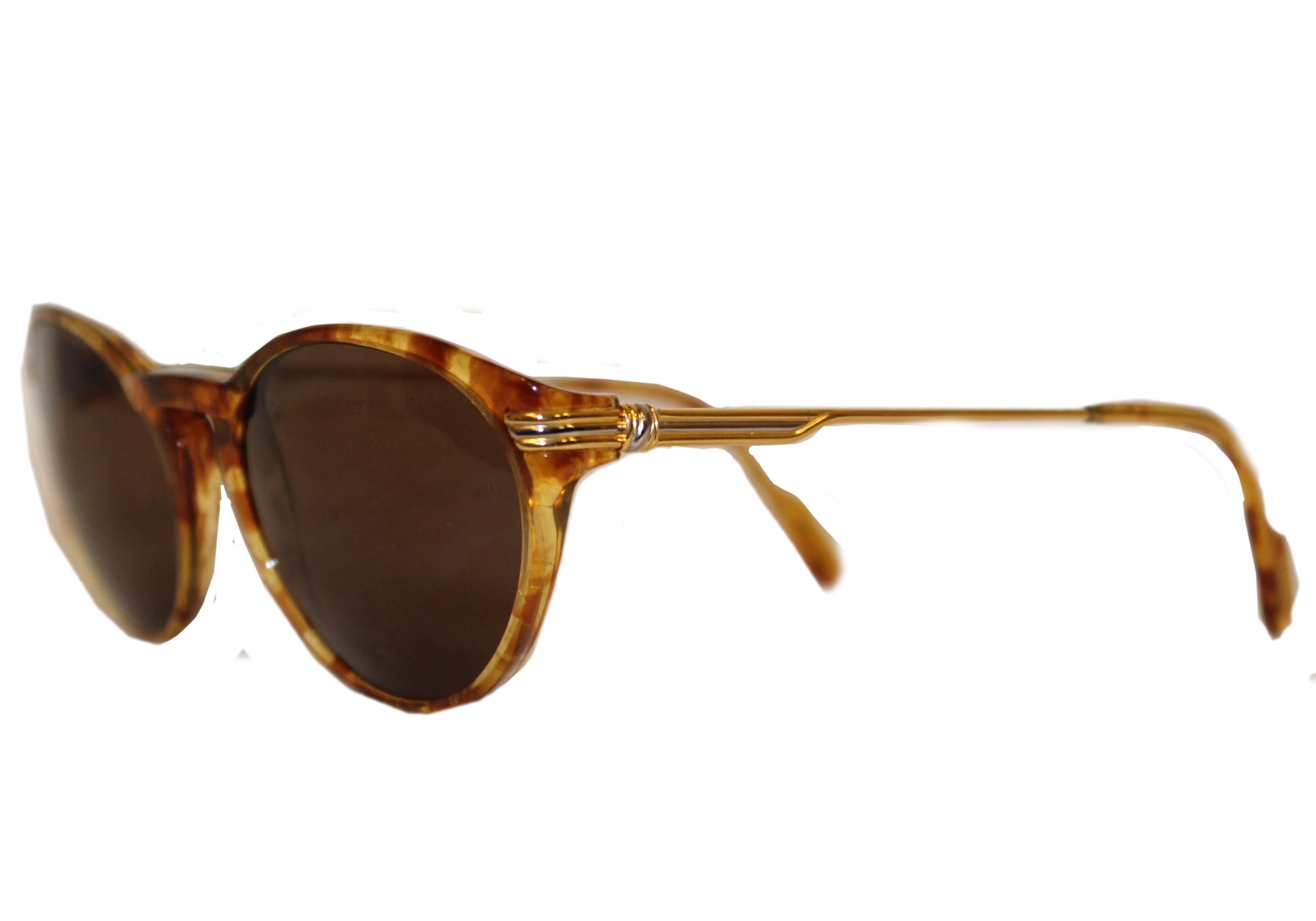 Cartier Cat Eye tortoise shell motif sunglasses with 135 mm temples and gold tone metal details on temples and hinges.  A Cartier logo plaque is featured at the end of each temple.   The Cartier work has stood the test of time and every woman, no