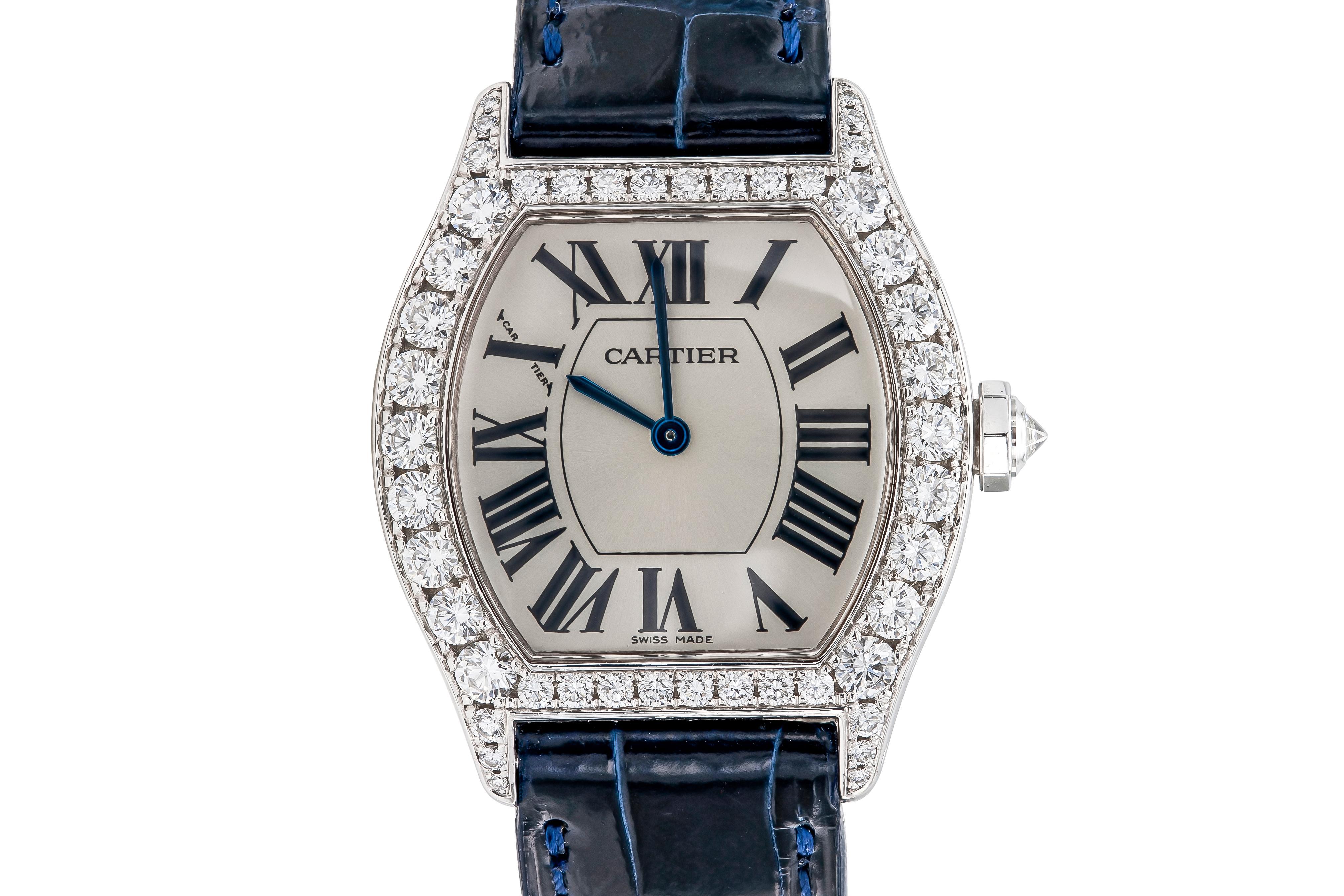 Finement réalisée en or blanc 18 carats avec des diamants ronds de taille Brilliante et un bracelet en cuir d'alligator bleu marine.
Signé par Cartier
Face de 28 mm
Modèle #2644