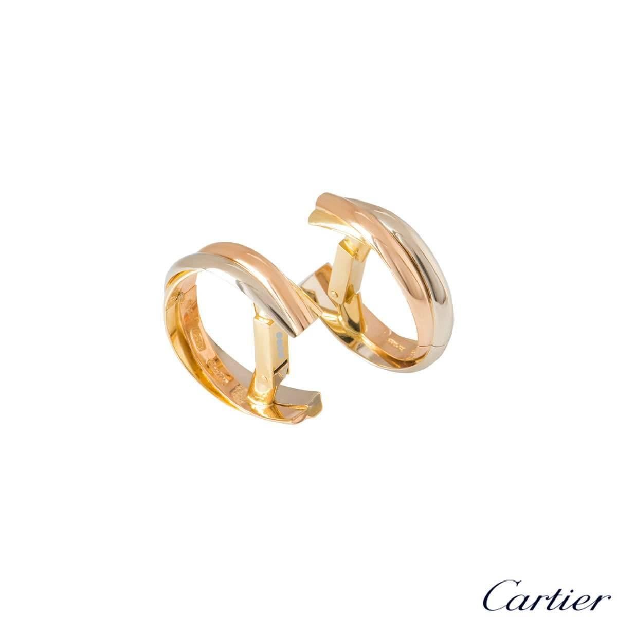 A pair of 18k tri-colour gold Trinity cufflinks by Cartier. The cufflinks are made up of three interwoven gold bands in yellow, white and rose gold with a polished finish, complete with a lever hinge fitting and bar connector. The cufflinks measure