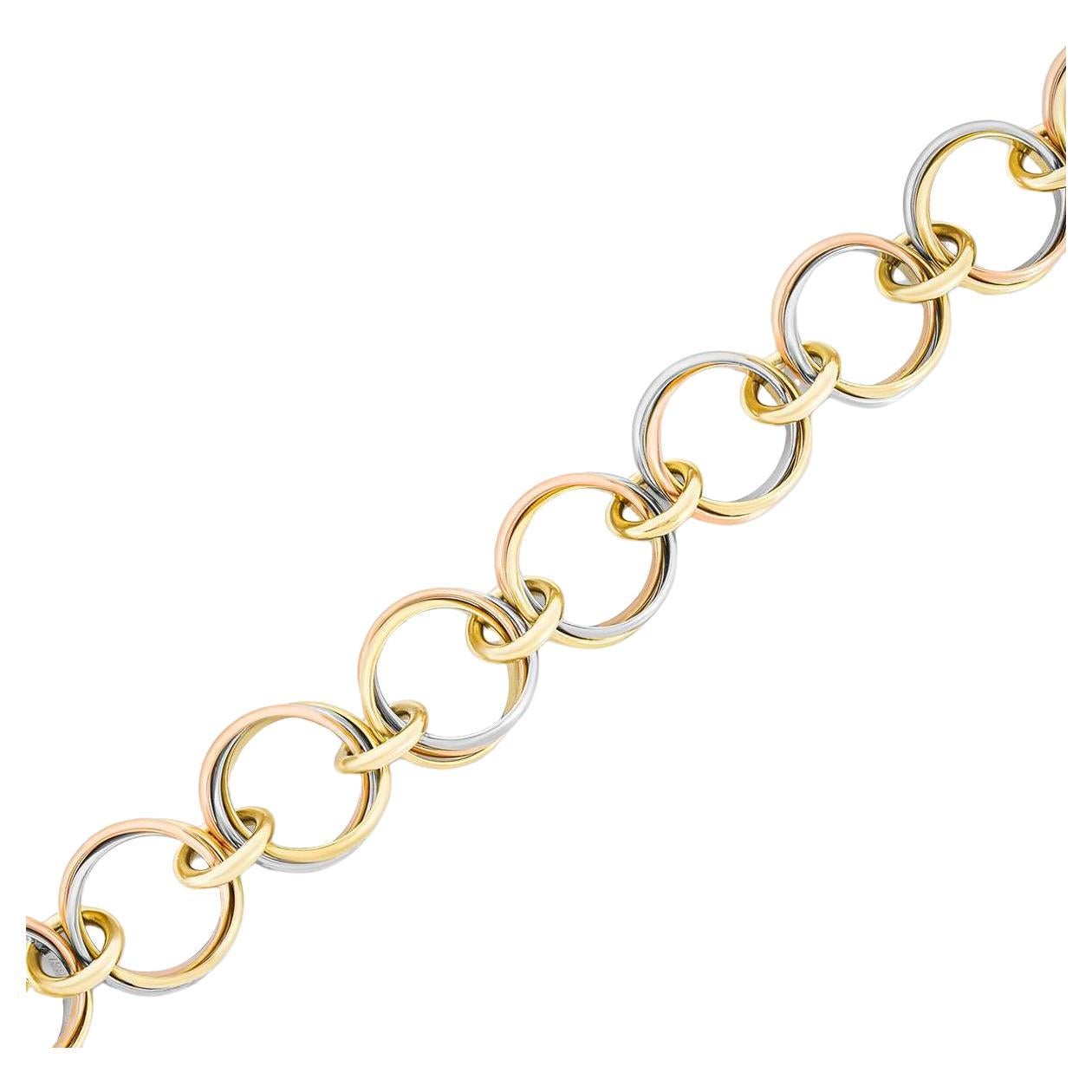 An intricate 18k tri-colour gold link bracelet by Cartier from the Trinity collection. The bracelet consists of 10 stations of intertwined 18k white, rose and yellow gold circular motifs joined by nine yellow gold links. The 7.5inch long bracelet