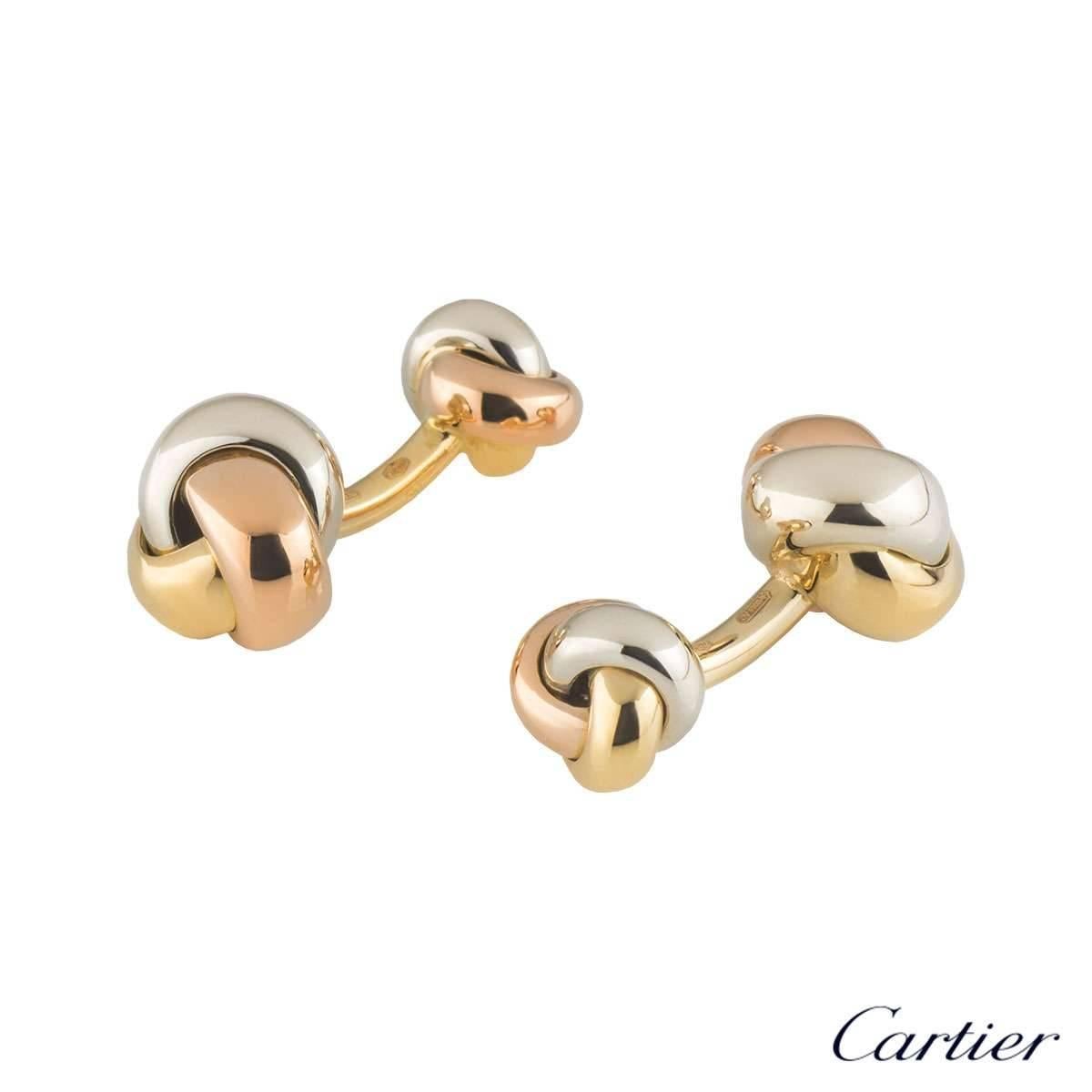 A classic pair of 18k tri-colour gold Cartier Trinity cufflinks. The cufflinks are composed of a white, yellow and rose gold band interwoven into a large knot leading to a smaller knot. The large knot measures 11.5mm in diameter and the smaller knot