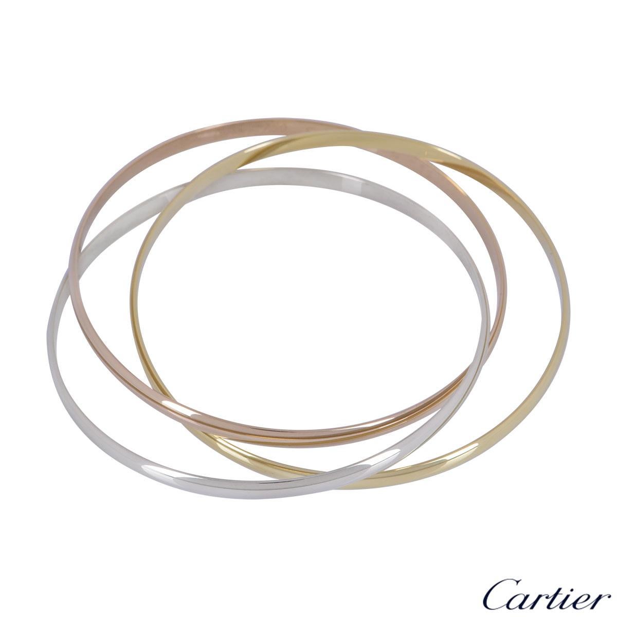 An iconic 18k tri-colour gold bangle by Cartier from the Trinity De Cartier collection. The bracelet is made up of three intertwined 18k rose, white and yellow gold 4mm bands. The bracelet is a 18cm and has a gross weight of 14.53 grams. 

The