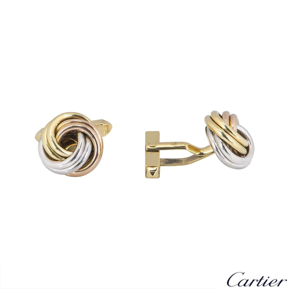 An 18k pair of tri-colour gold cufflinks by Cartier from the Trinity collection. The cufflinks are composed of a white, yellow and rose gold band interwoven into a large knot. The large knot measures 15.71mm in diameter with a classic hinged T-bar