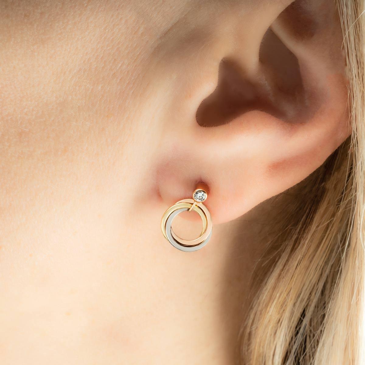 A beautiful pair of 18k tri-colour gold drop earrings from the Trinity de Cartier collection by Cartier. The earrings are each composed of a single round brilliant cut diamond, which have an approximate total diamond weight of 0.11ct, well matched
