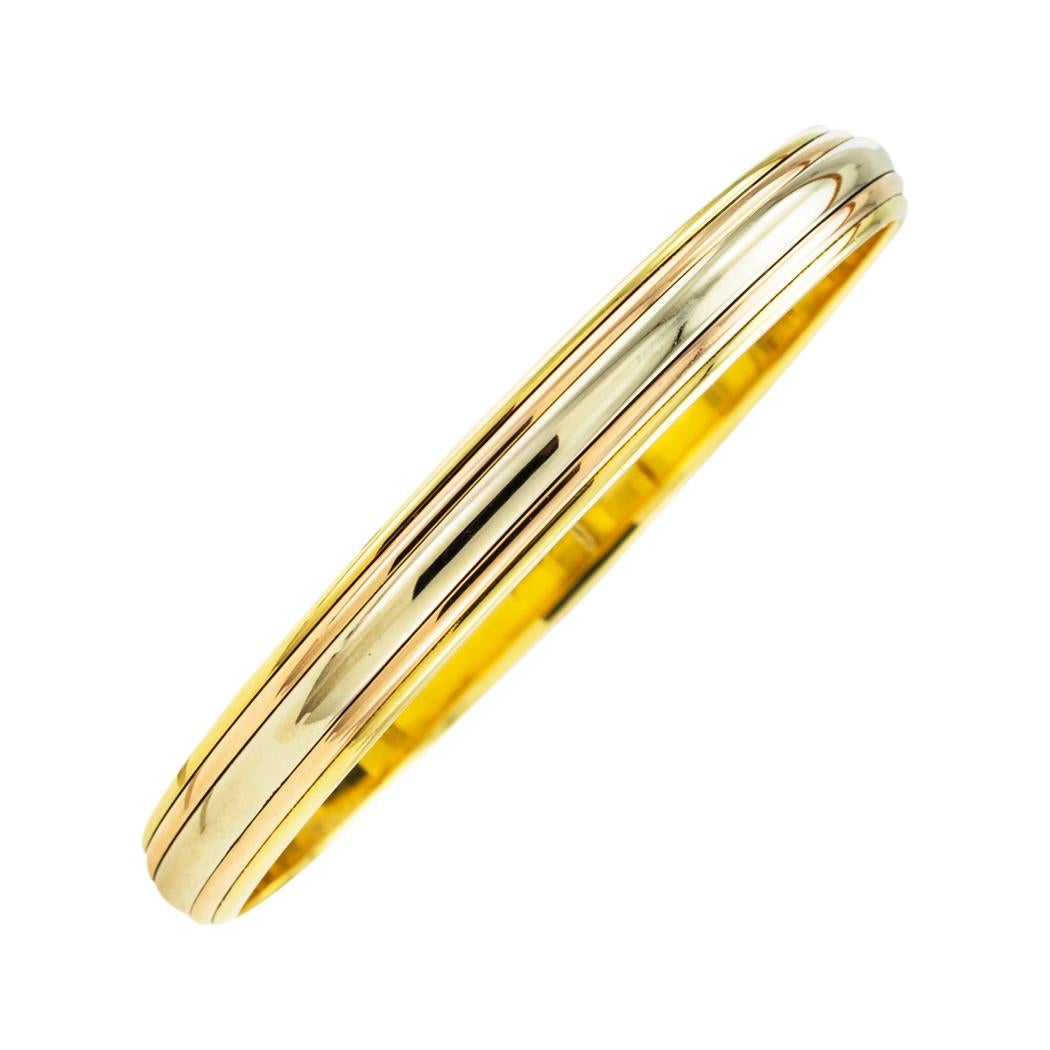 Cartier tricolor gold slip-on bangle bracelet. *

ABOUT THIS ITEM:  #B-DJ725A. Scroll down for detailed specifications.  The trinity of gold colors is a very distinctive Cartier look.  This slip-on bangle displays that color combination with subtle