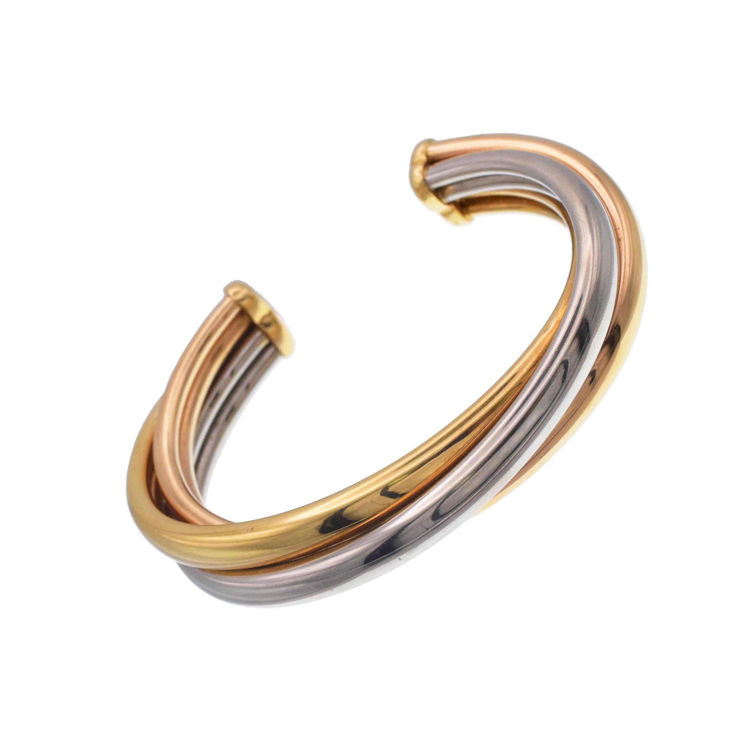 Cartier Tricolor Gold 'Trinity' Cuff Bangle Bracelet crafted in 18k tri tone gold.Consisting of 3 bangles - yellow, white and rose gold, interlocked together.
The bracelet has open back. Inscribed: Cartier, 1992, no.
B92344. Inner circle measures