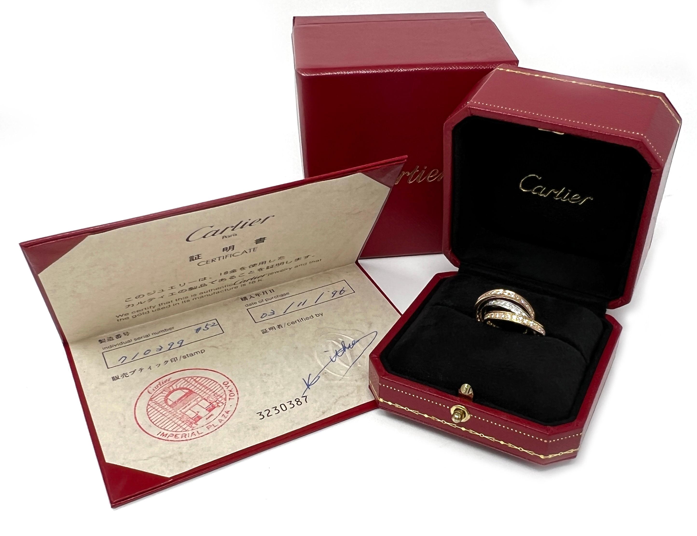 This is an elite authentic band ring by Cartier from the Trinity collection. It is crafted from 18k yellow, white and rose gold with a polished finish featuring a triple interlaced band with the three color gold, each set with a full circle of
